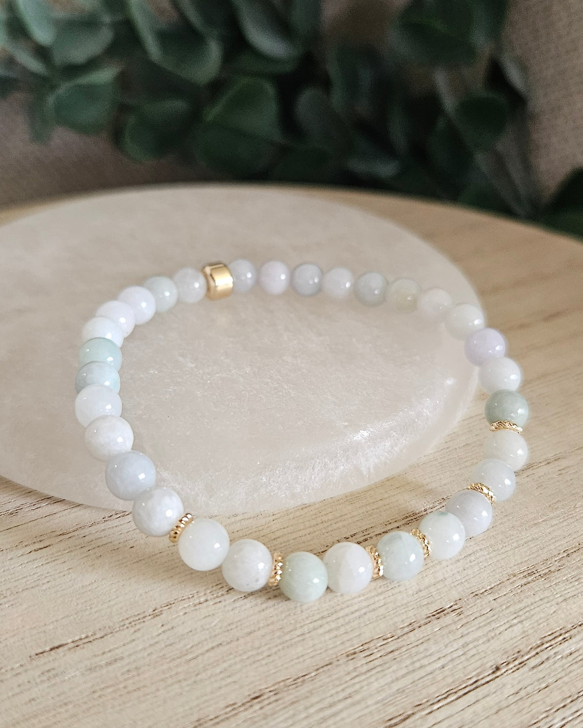 Burmese Jade Grace bracelet with soft green gemstone beads and 14k gold-plated accents displayed on selenite