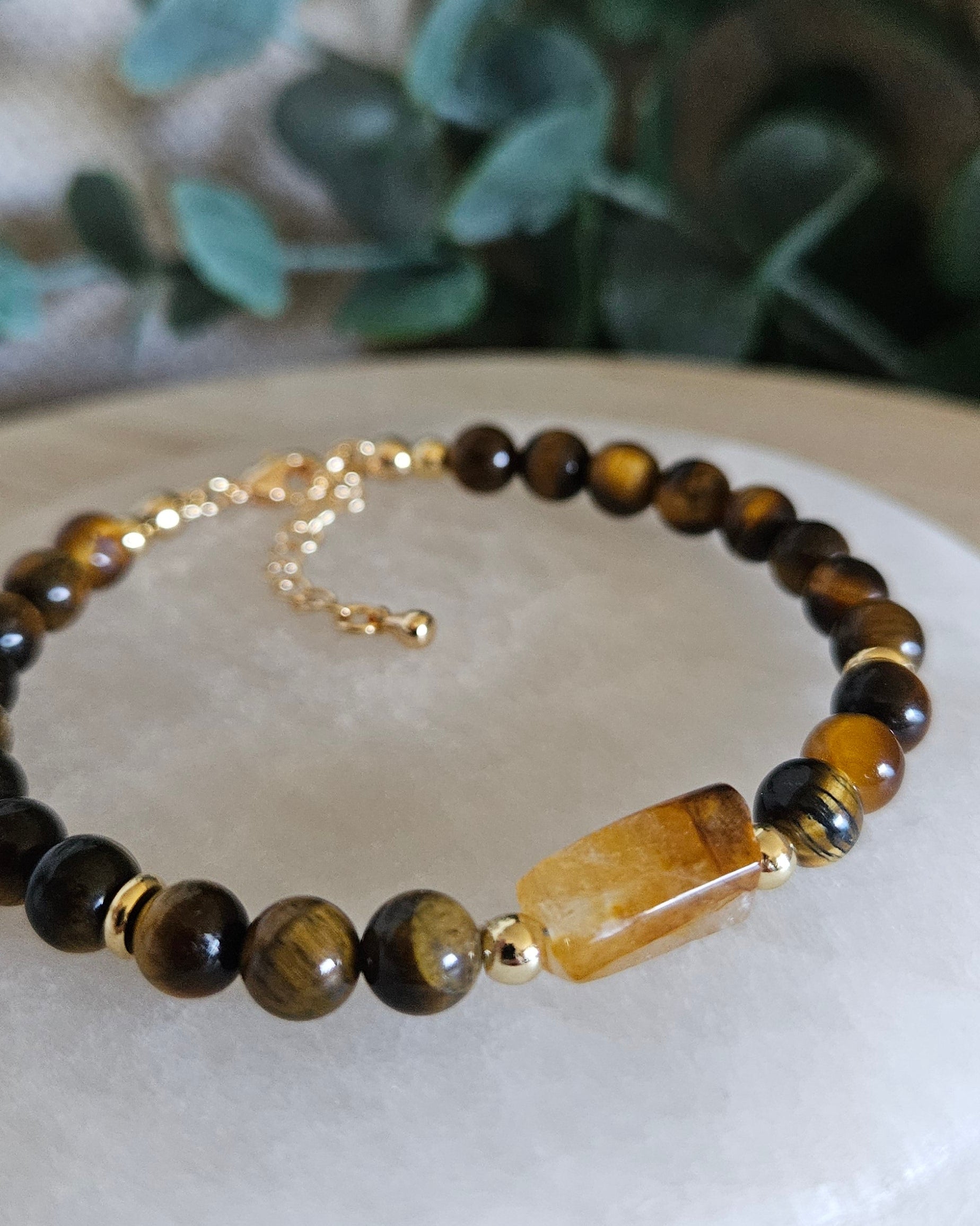 Angled close-up of the Citrine focal and brown-gold Tiger’s Eye beads on a selenite plate