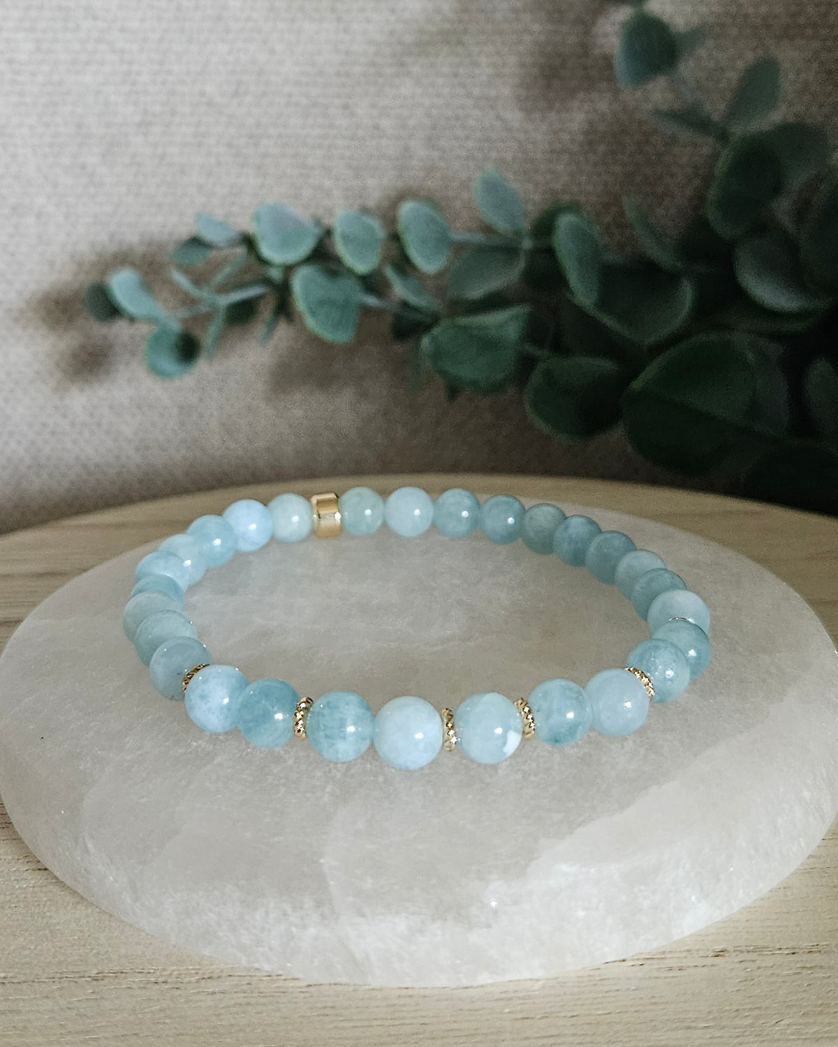 Aquamarine Grace bracelet with pale blue gemstone beads and 14k gold-plated accents displayed on selenite