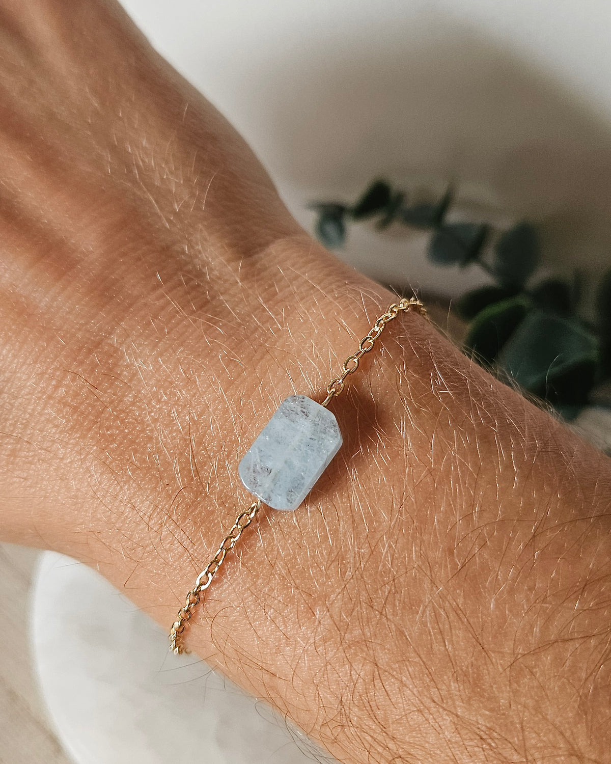 Aquamarine Whisper bracelet worn on wrist showing the soft blue rectangular gemstone focal and delicate gold-plated chain