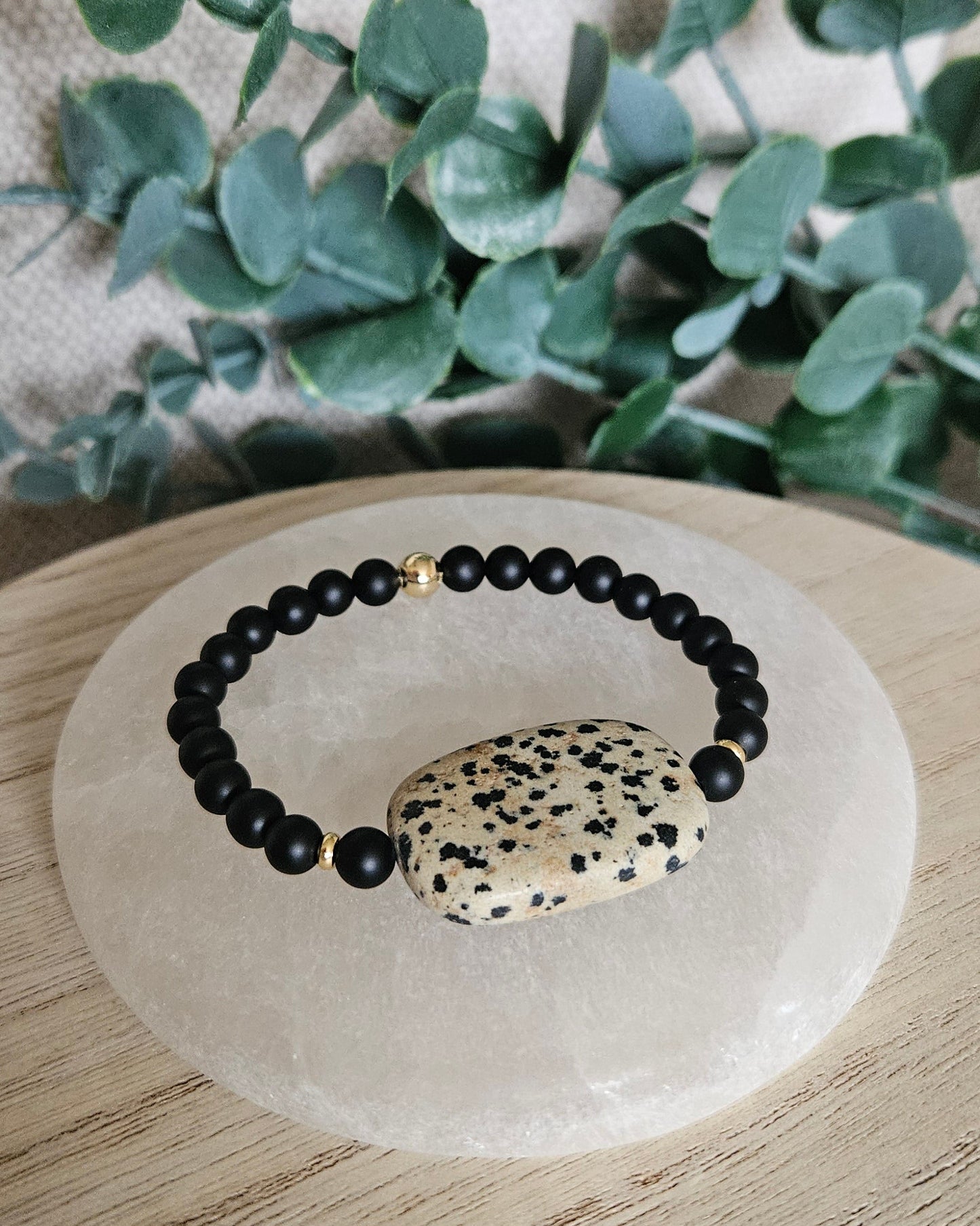 Full view of the Black Onyx bracelet and oversized Dalmatian Jasper focal displayed on selenite
