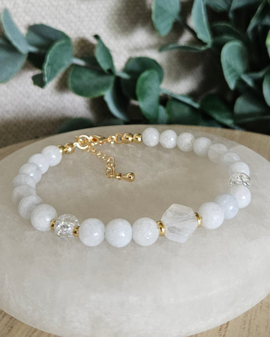 Celestite bracelet with a hexagon-cut Moonstone focal, Cracked Quartz accents and gold details on a round selenite plate