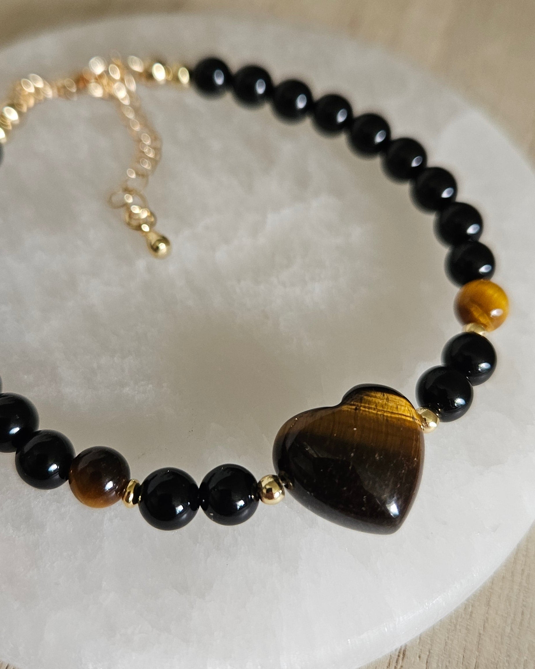 Close-up of the striped Tiger's Eye heart focal, Black Onyx beads and gold-plated accents