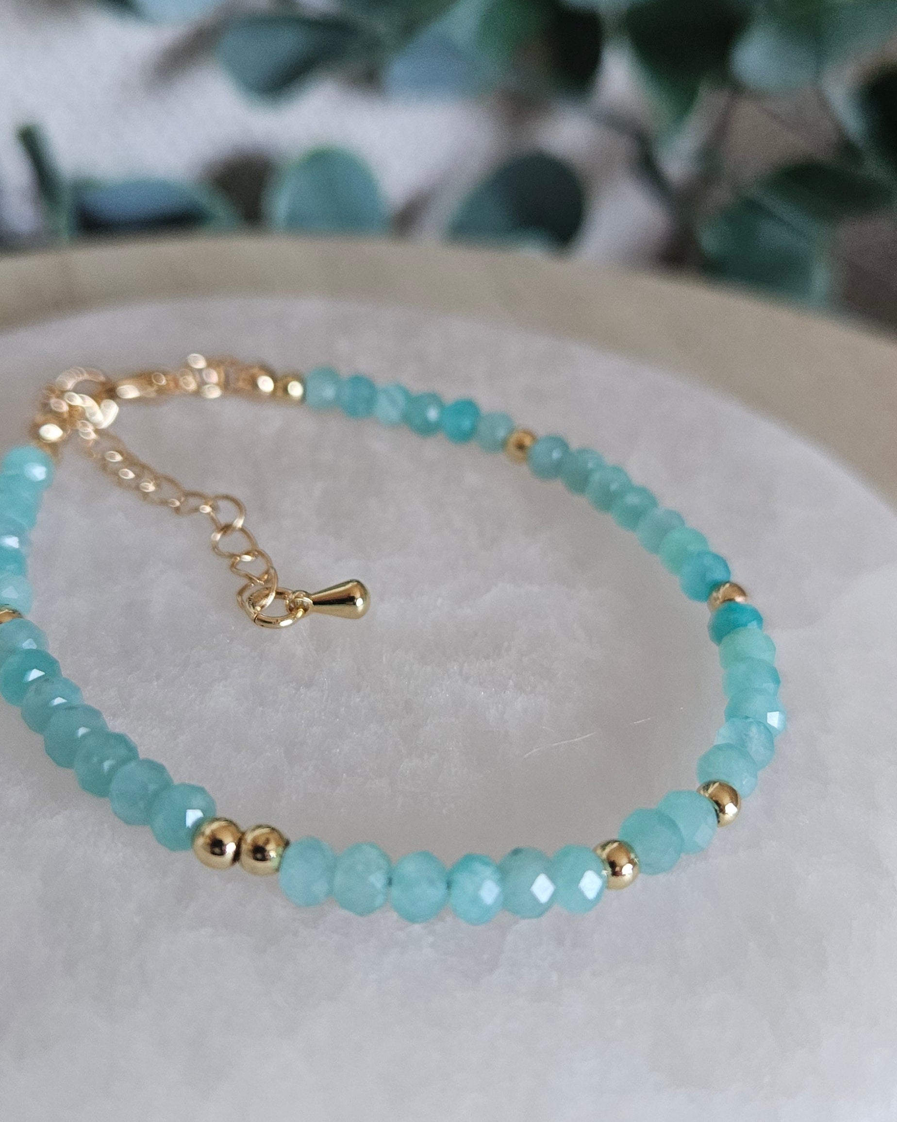 Close-up of aqua-blue Mozambique Amazonite beads with polished gold-plated spacer accents