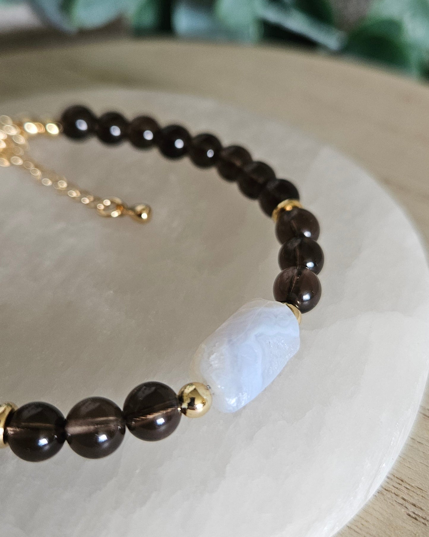 Close-up of the softly banded Blue Lace Agate focal, translucent Smoky Quartz beads and gold accents