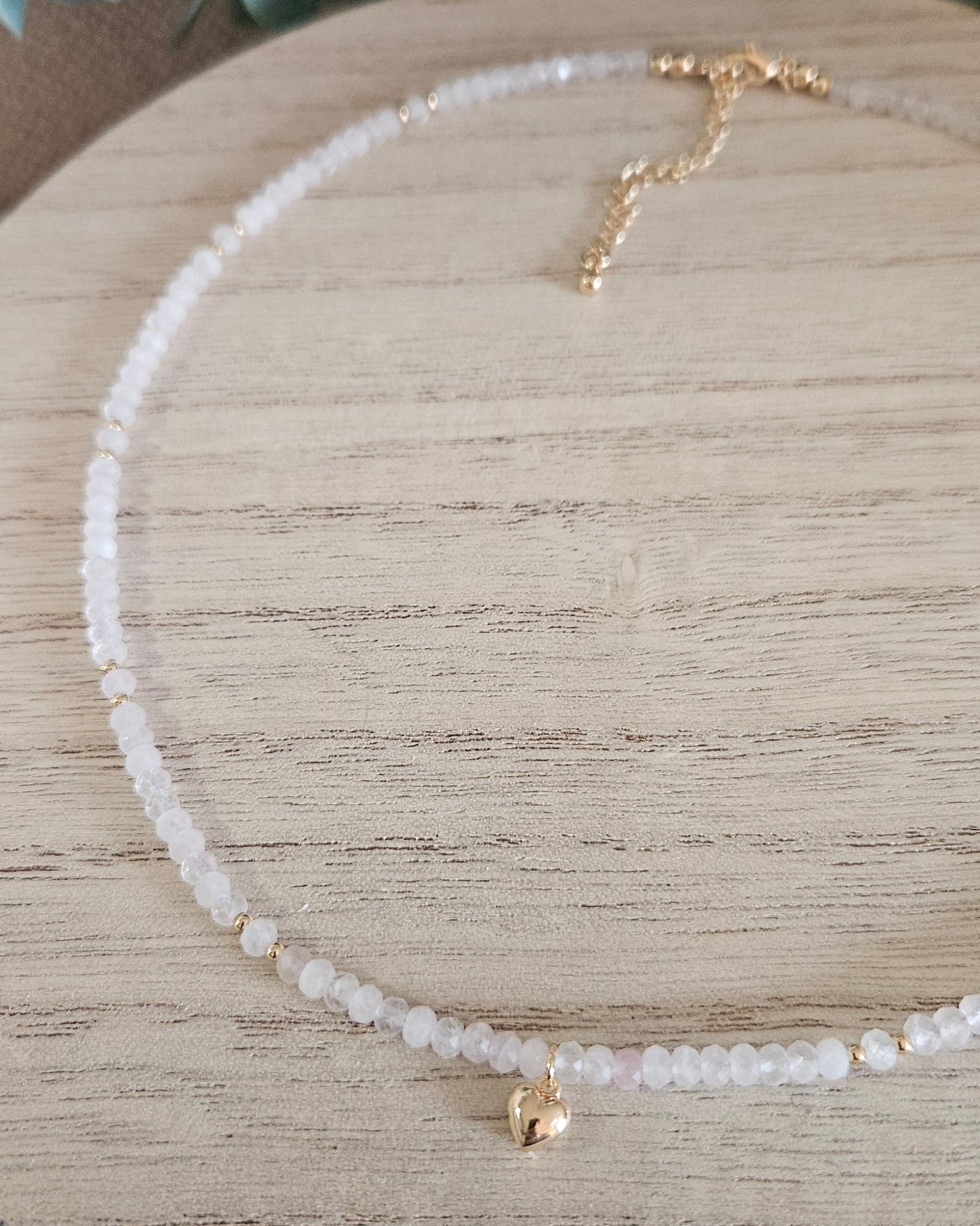 Close overhead view of the Rose Quartz necklace with heart pendant, clasp and extender chain