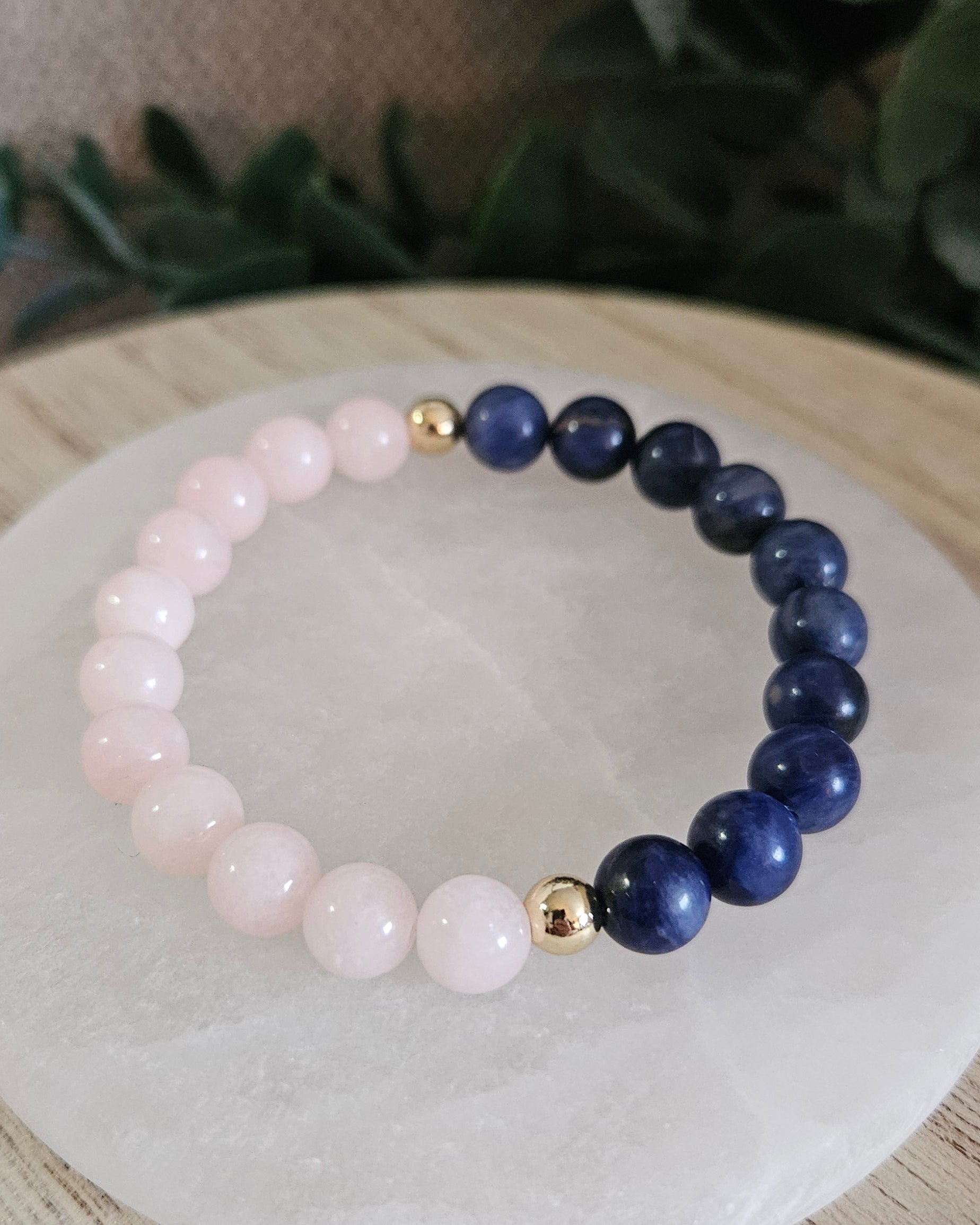 Close view of polished Peach Jade and Sodalite beads separated by two gold-plated accent beads