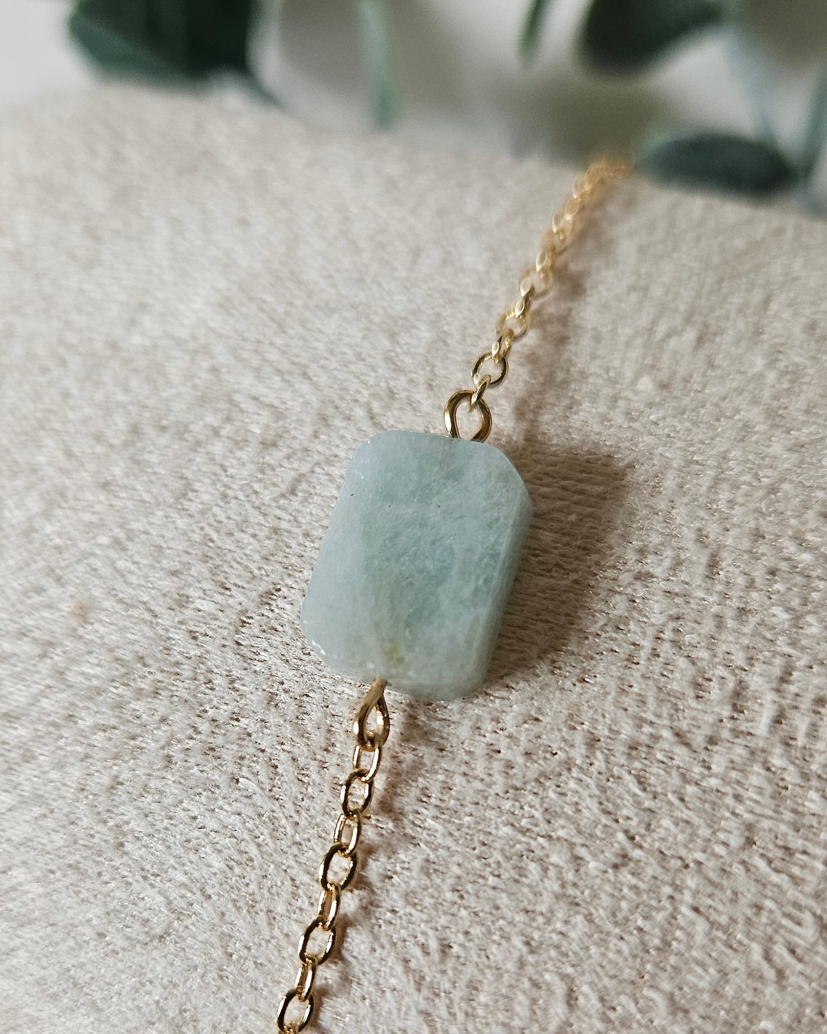 Close view of the Aquamarine rectangular focal on a fine gold-plated chain bracelet with soft neutral styling