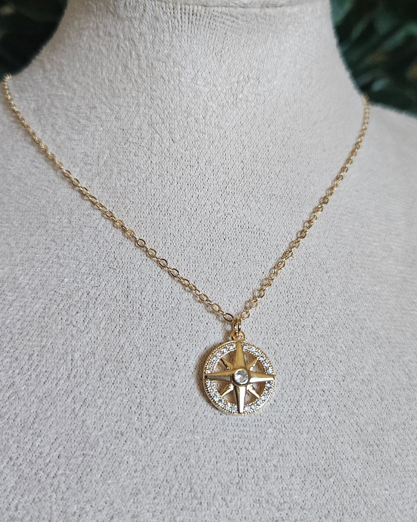 Closer view of the North Star necklace and round cubic zirconia pendant on a beige jewellery bust