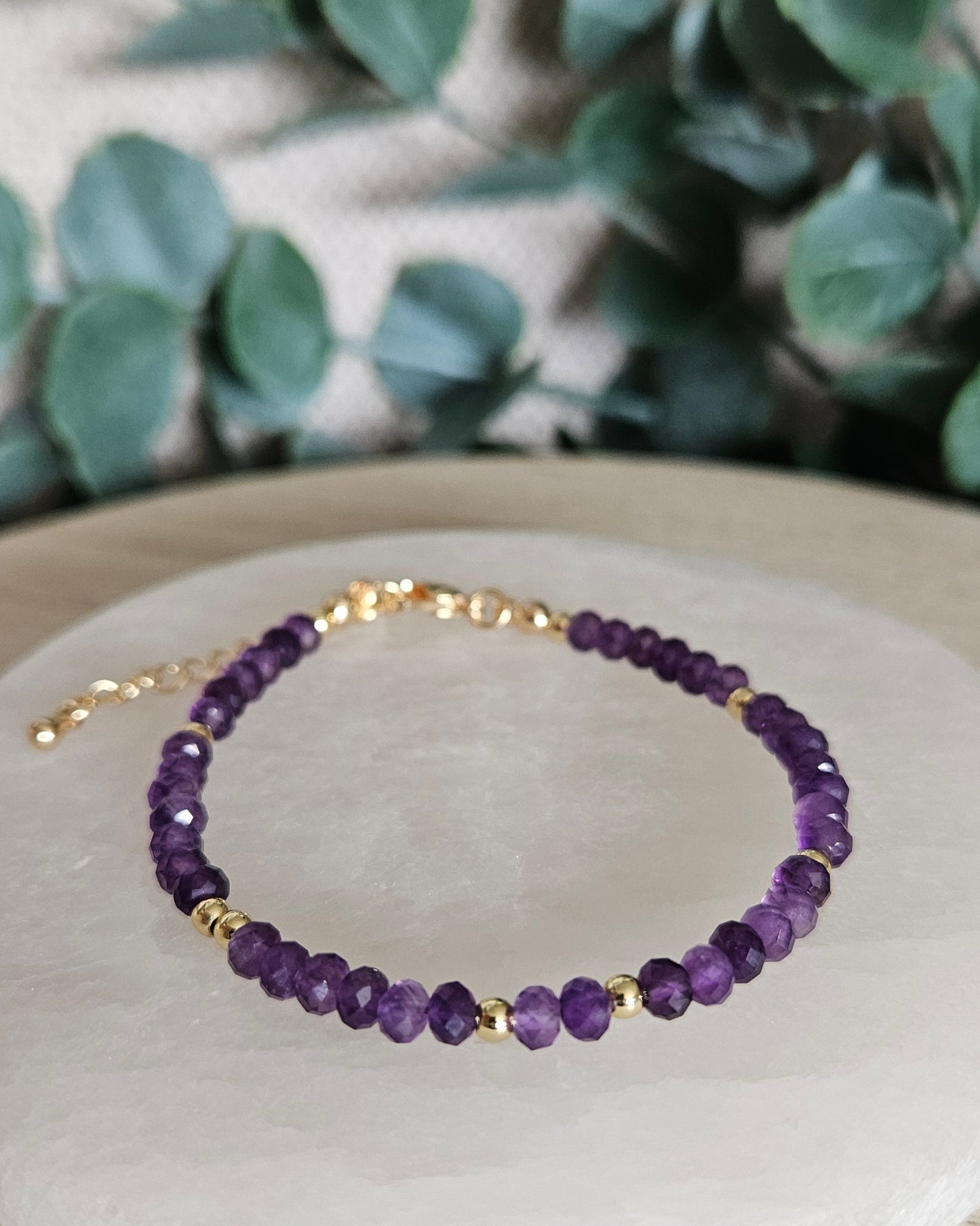 Front angled view of the faceted Amethyst bracelet with polished gold-plated spacer beads