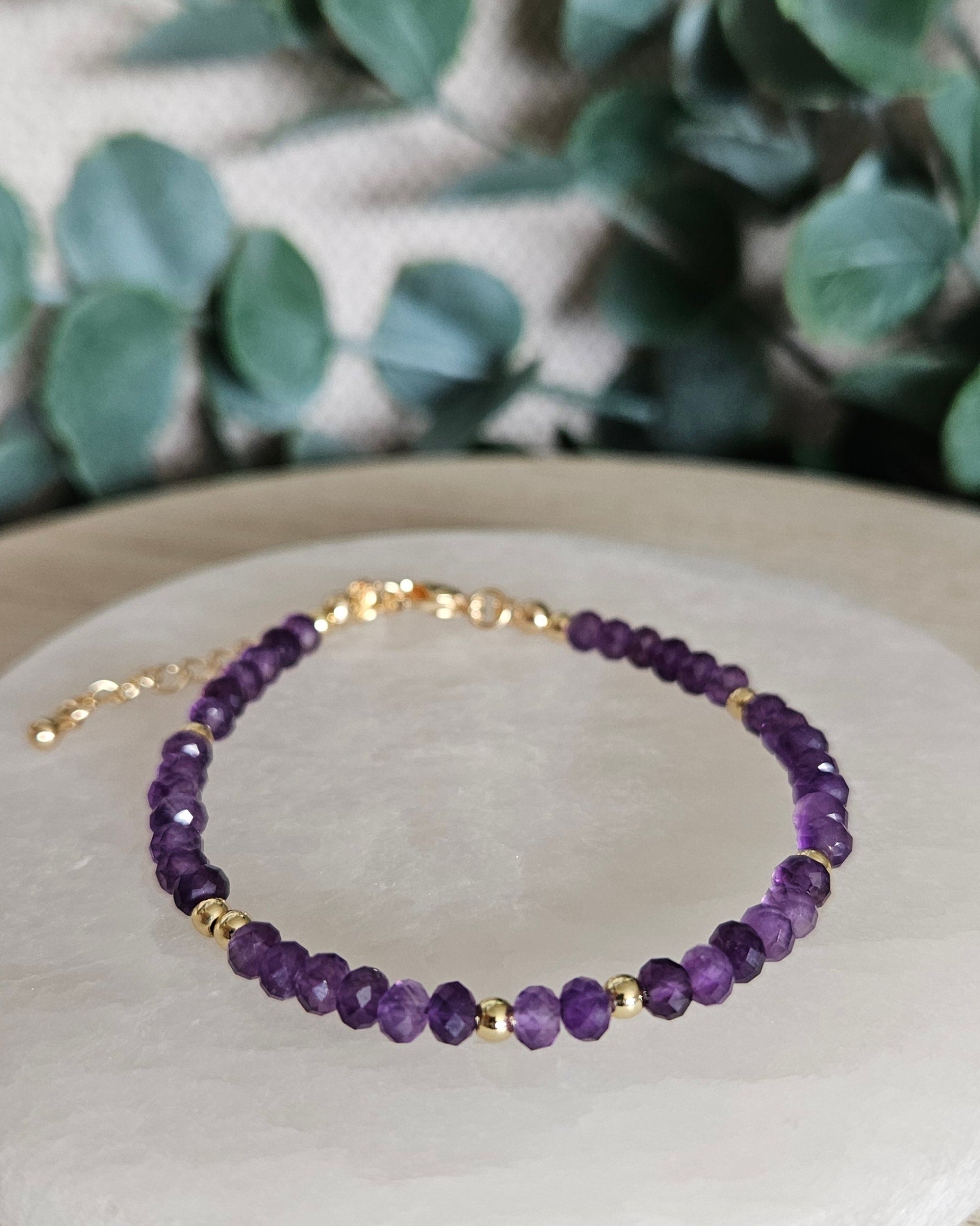 Front angled view of the faceted Amethyst bracelet with polished gold-plated spacer beads
