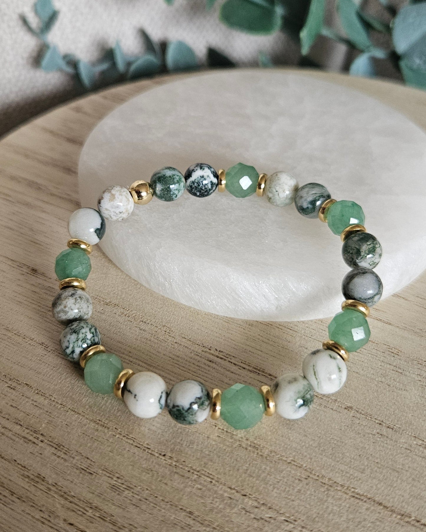Full Green Aventurine and Tree Agate stretch bracelet displayed on a pale round stone tra