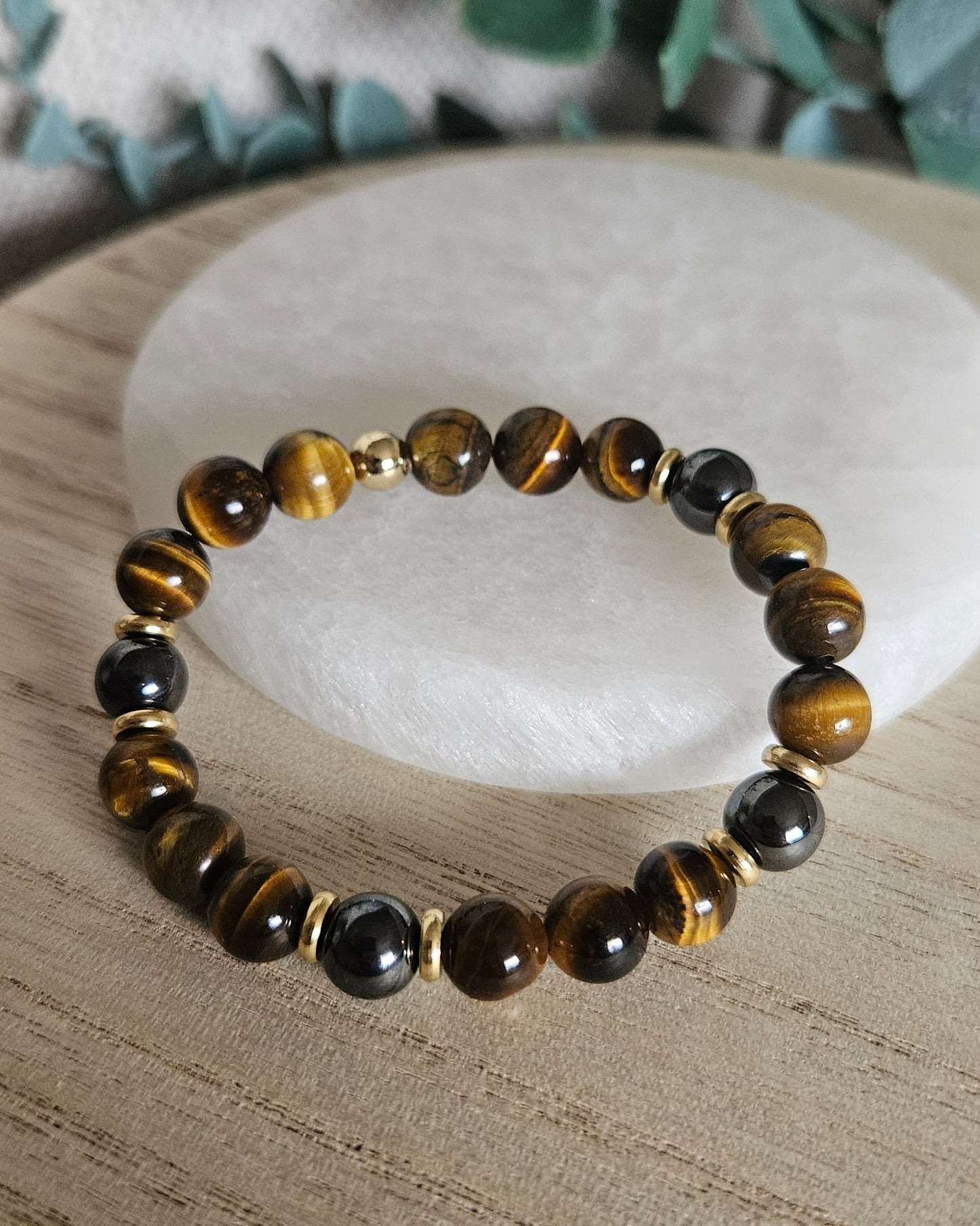Full Tiger’s Eye and Hematite stretch bracelet with gold-plated spacers displayed on a wooden surface