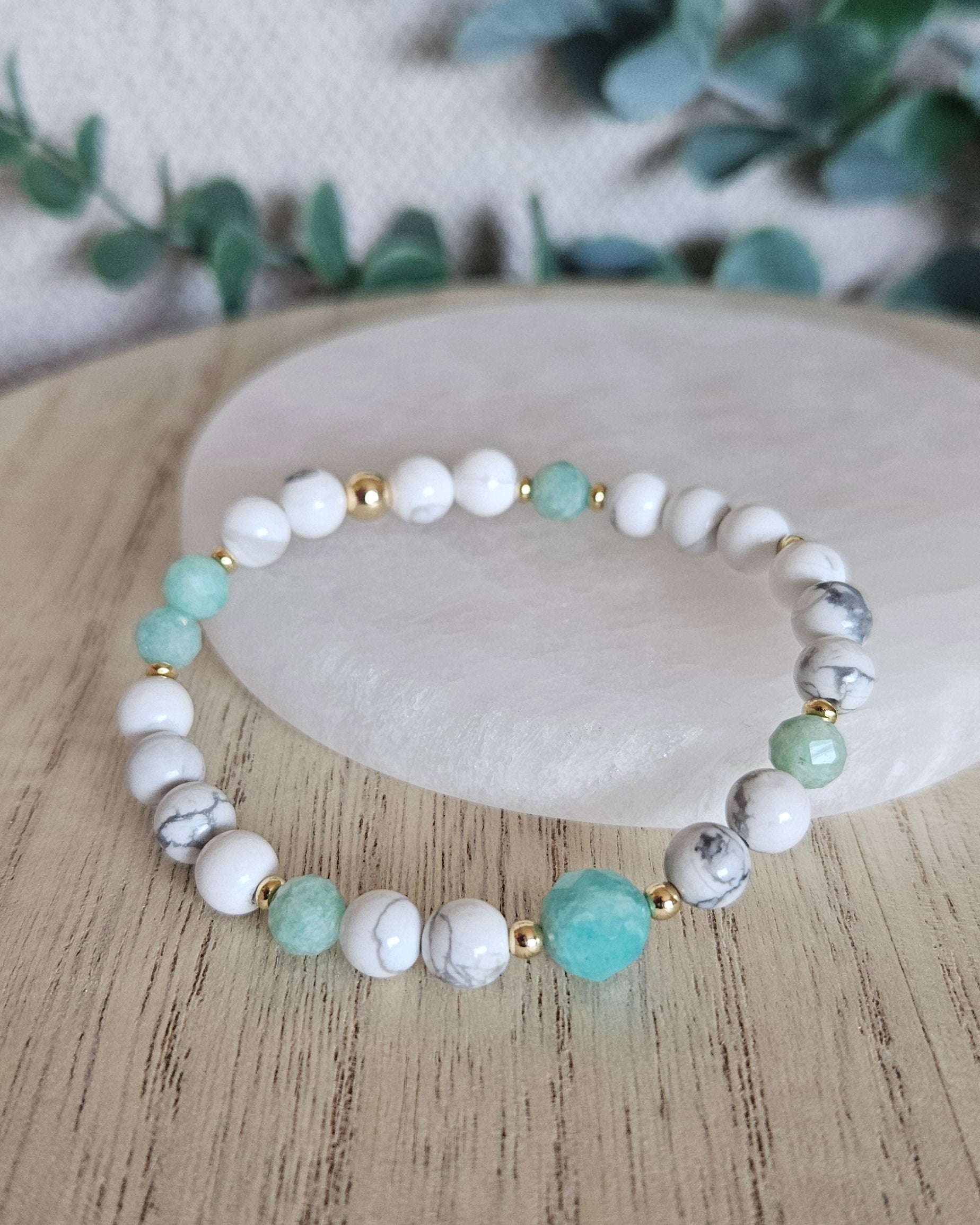 Howlite and Amazonite bracelet arranged before a round selenite plate with eucalyptus in the background