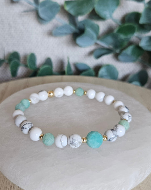Howlite and Amazonite stretch bracelet with mint-green faceted accents and gold-plated spacers displayed on selenite