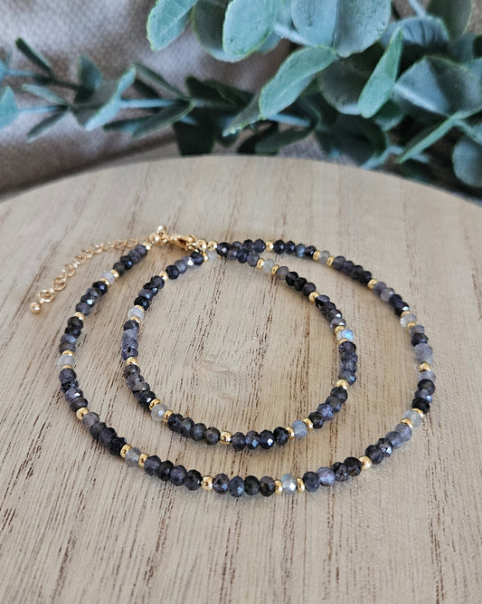 Iolite and Labradorite necklace loosely coiled on a wooden display with its clasp and extender chain visible