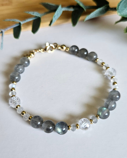 Labradorite, Moonstone and cubic zirconia bracelet with gold-plated accents and clasp on a white surface