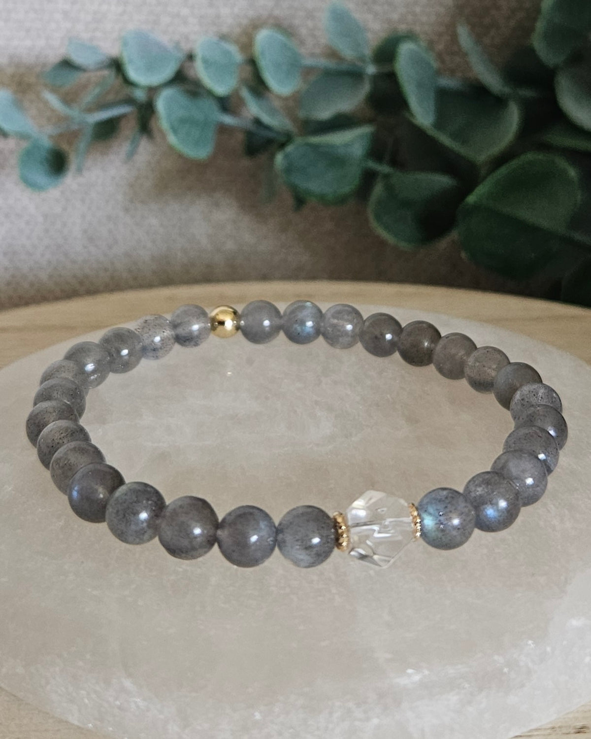 Labradorite Still bracelet with 6mm grey gemstone beads, Clear Quartz hexagon focal and 14k gold-plated accents displayed on selenite