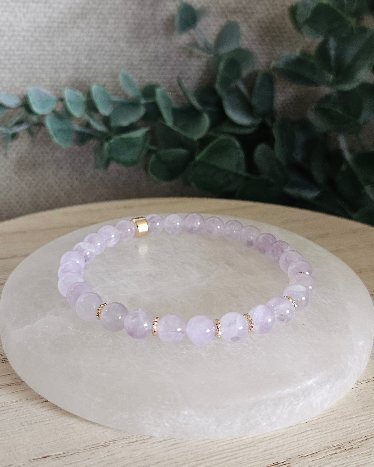 Lavender Amethyst Grace bracelet with 6mm pale purple gemstone beads, 14k gold-plated accents and focal bead displayed on selenite