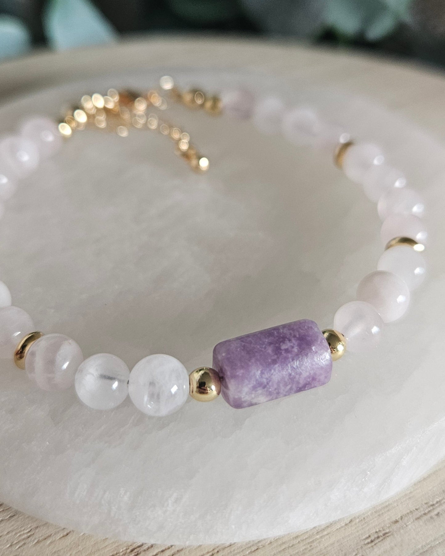Macro close-up of the purple Lepidolite focal stone, Rose Quartz beads and polished gold-plated accents