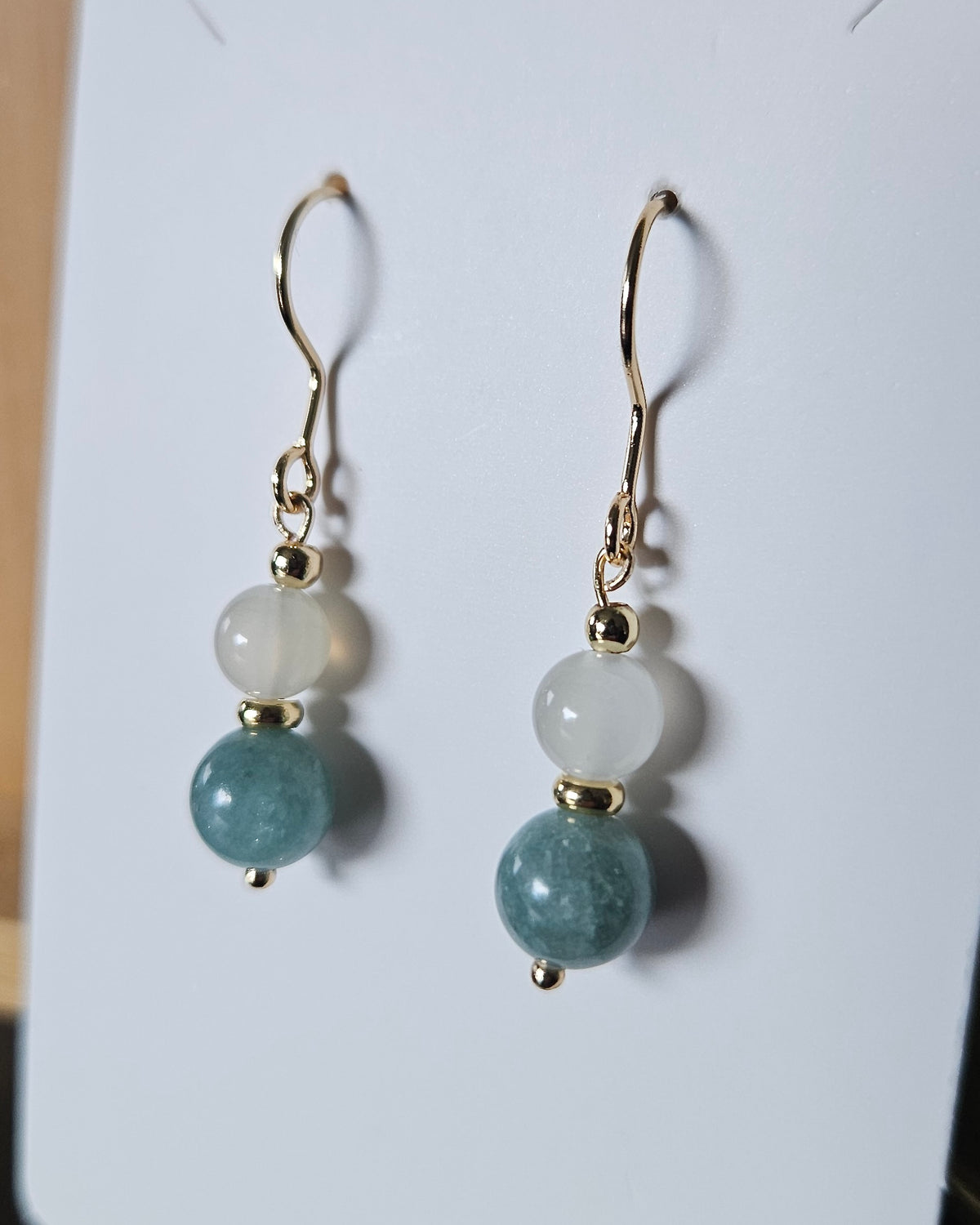 Moonstone and Sage Green Jade earrings displayed on a white earring card with gold-plated stainless steel hooks