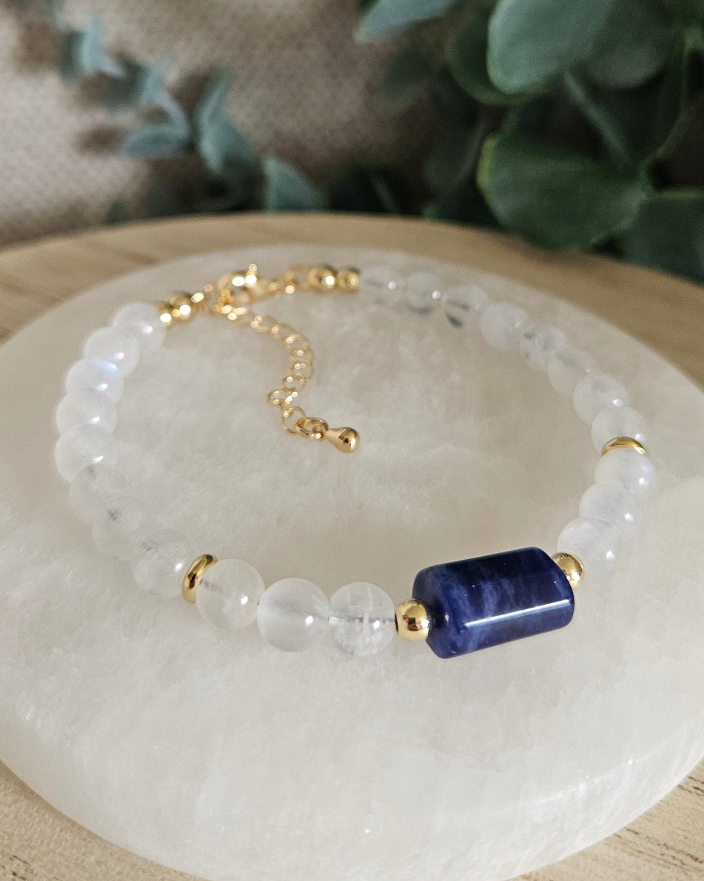Moonstone bracelet with a deep-blue rectangular Sodalite focal, gold-plated accents and extender chain on selenite