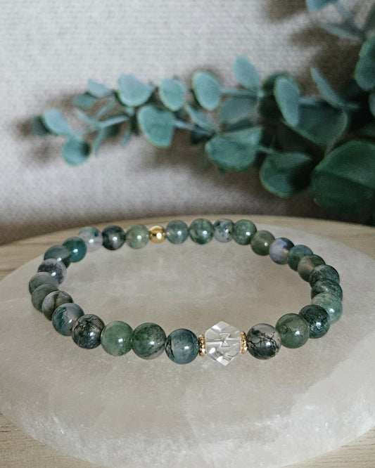 Moss Agate Still bracelet with 6mm green gemstone beads, Clear Quartz hexagon focal and 14k gold-plated accents displayed on selenite