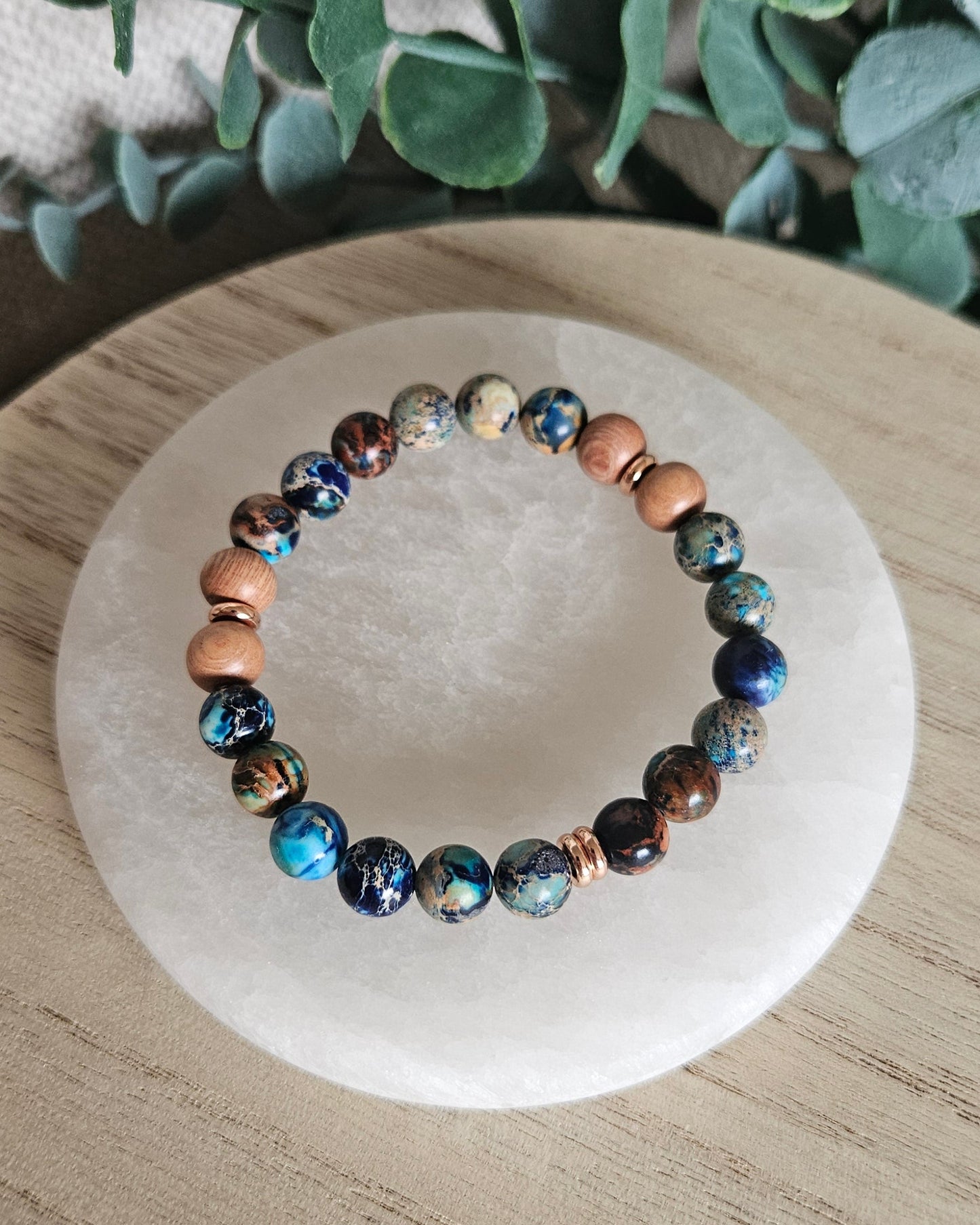 Overhead view of blue Sea Sediment Jasper and natural Rosewood diffuser beads with rose gold-plated spacers