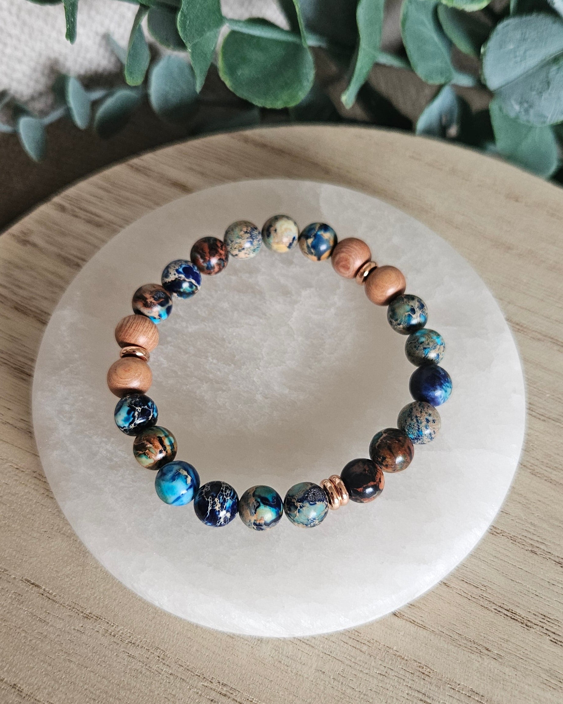 Overhead view of blue Sea Sediment Jasper and natural Rosewood diffuser beads with rose gold-plated spacers