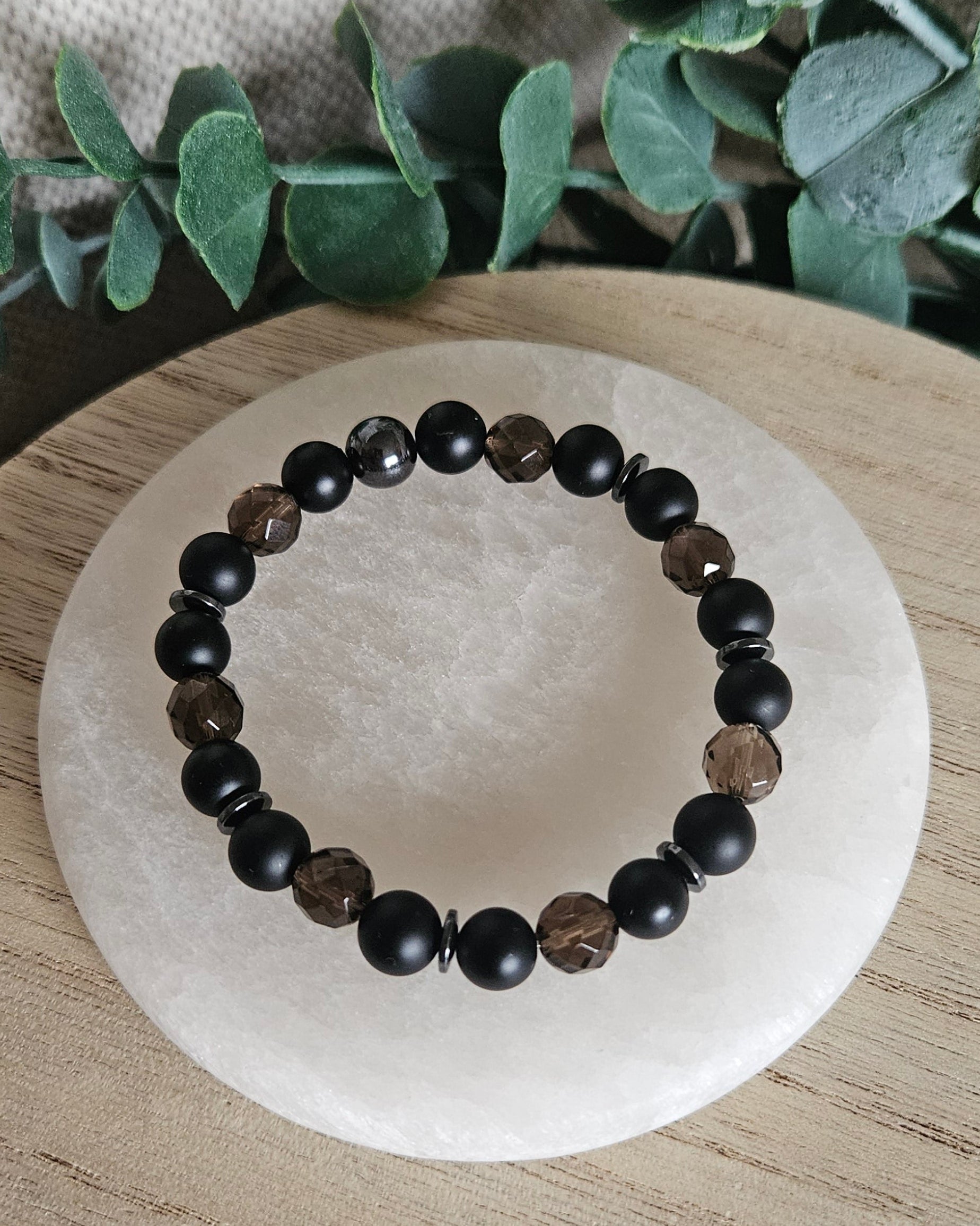 Overhead view of the Black Onyx bracelet with faceted Smoky Quartz beads and a single Hematite accent