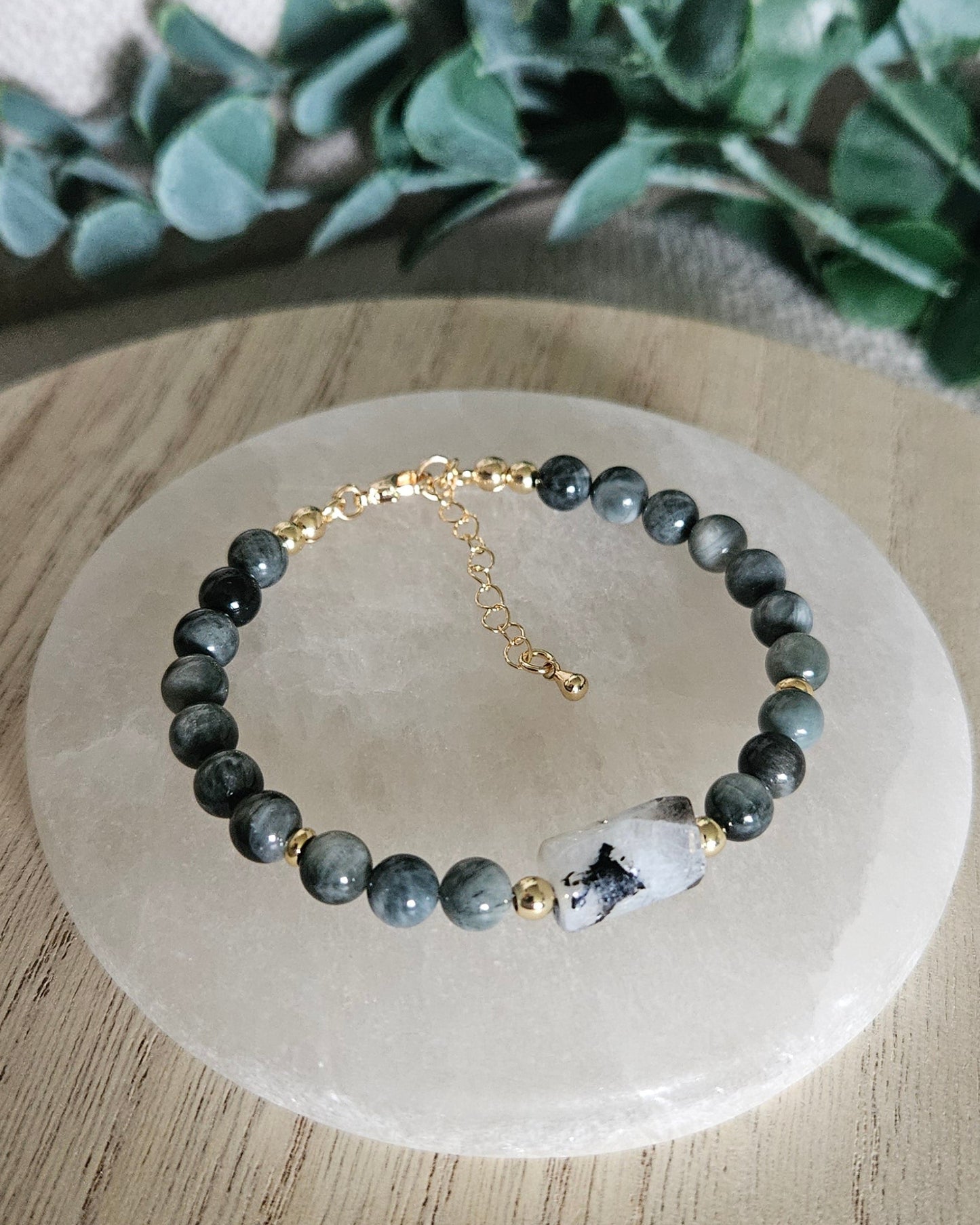 Overhead view of the Hawk’s Eye and Moonstone bracelet with gold-plated clasp and extender chain