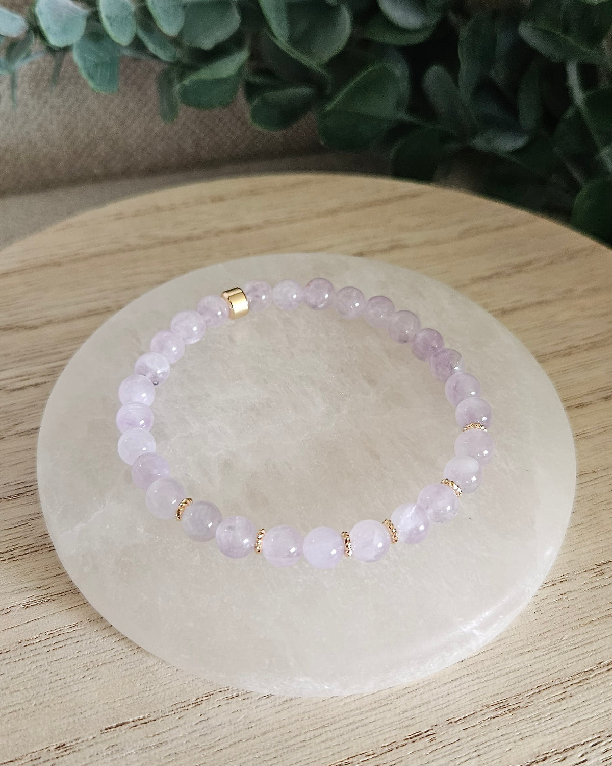 Overhead view of the Lavender Amethyst Grace bracelet with 6mm soft purple beads and 14k gold-plated accents on selenite