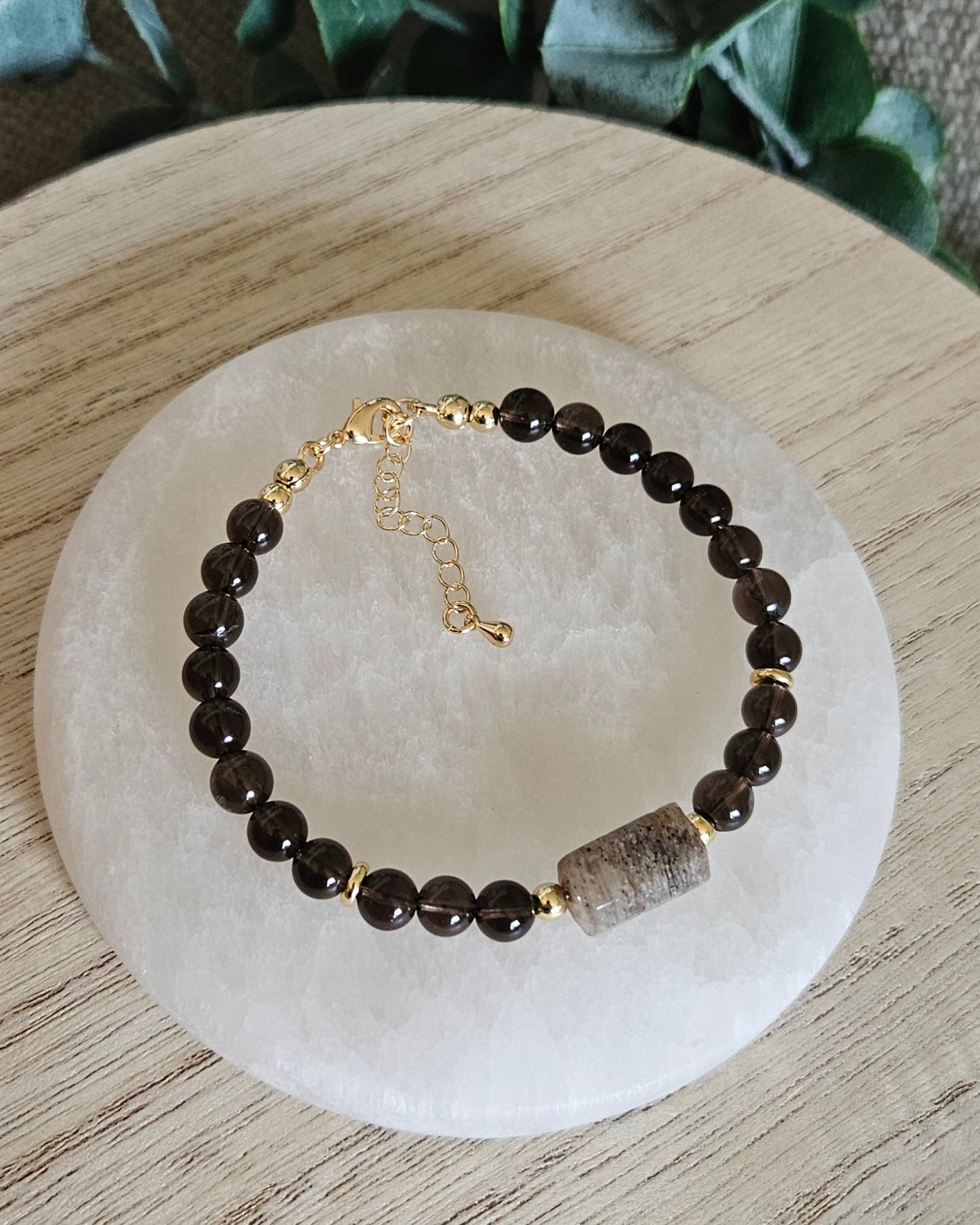 Overhead view of the Smoky Quartz and Angel Phantom Quartz bracelet with gold clasp and extender chain