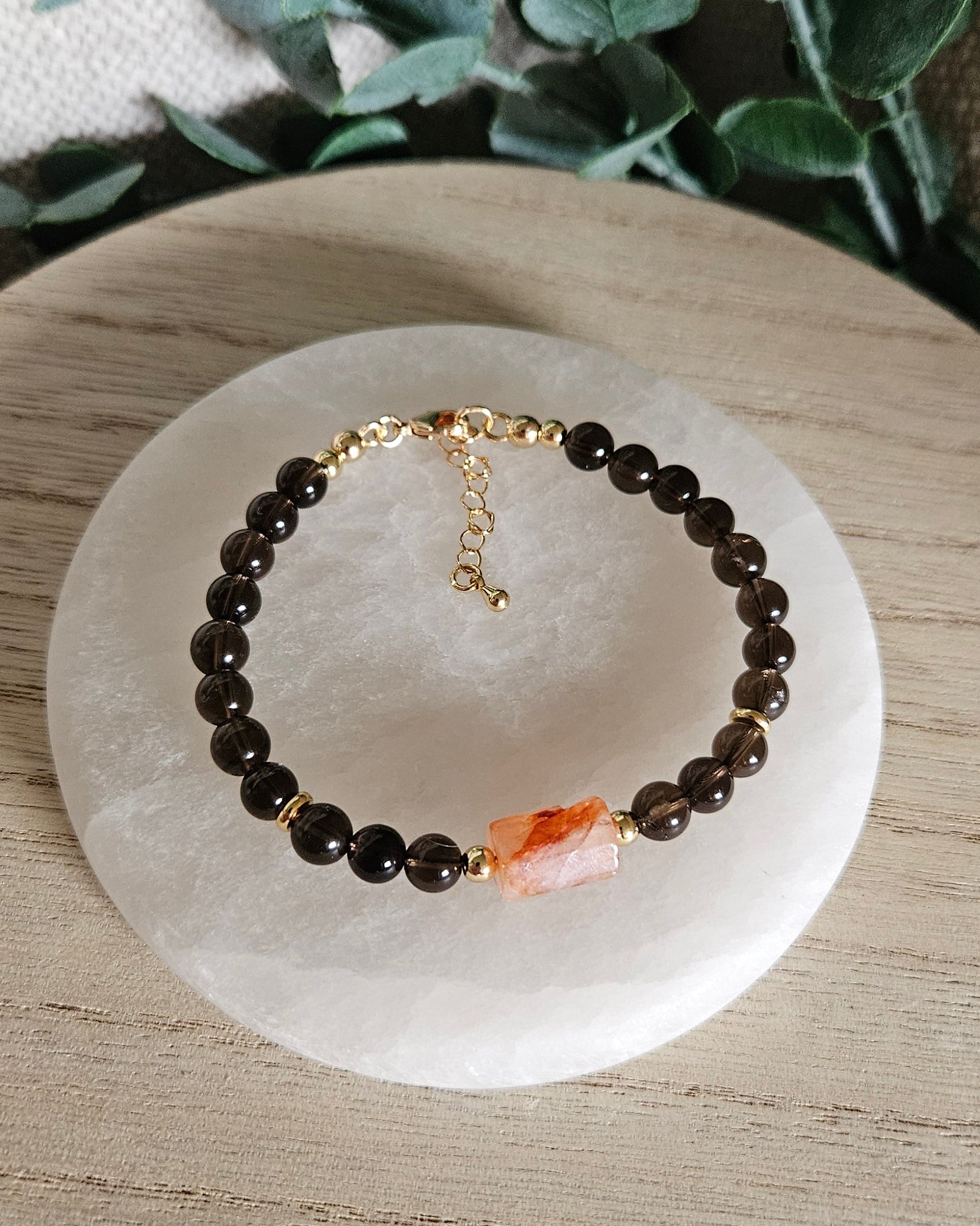Overhead view of the Smoky Quartz and Red Hematoid Quartz bracelet with gold clasp and extender chain