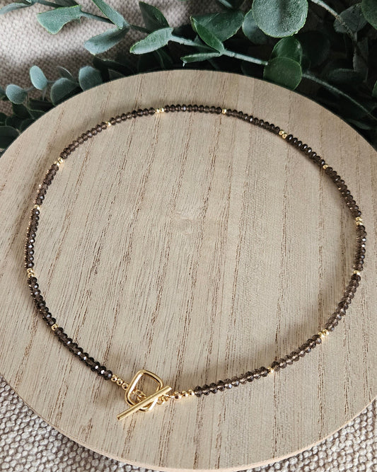 Overhead view of the complete 18-inch Smoky Quartz necklace arranged on a round wooden display
