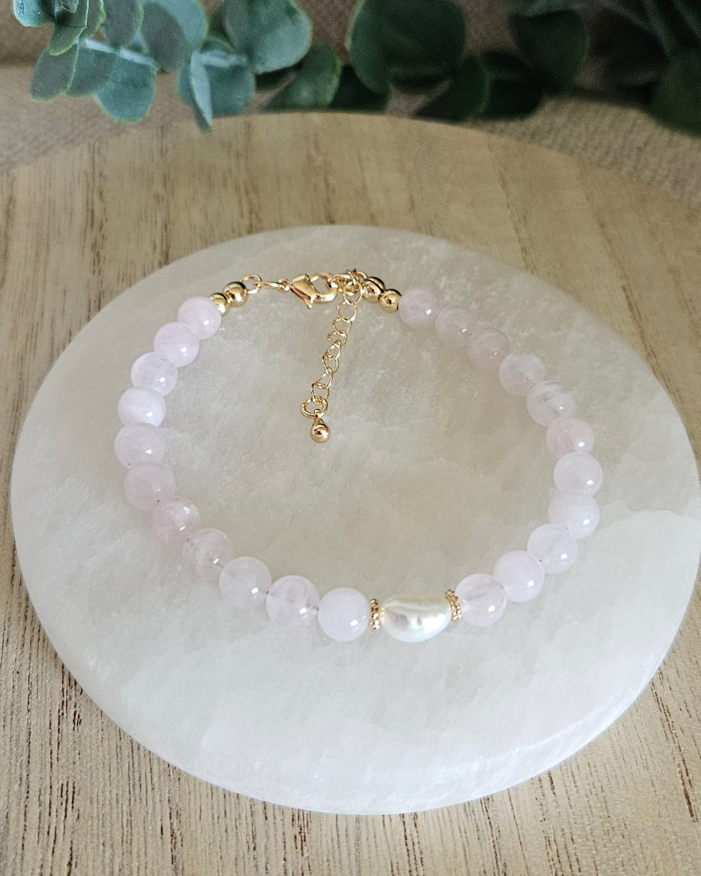 Overhead view of the Rose Quartz Embrace bracelet with freshwater pearl focal, clasp and extender chain