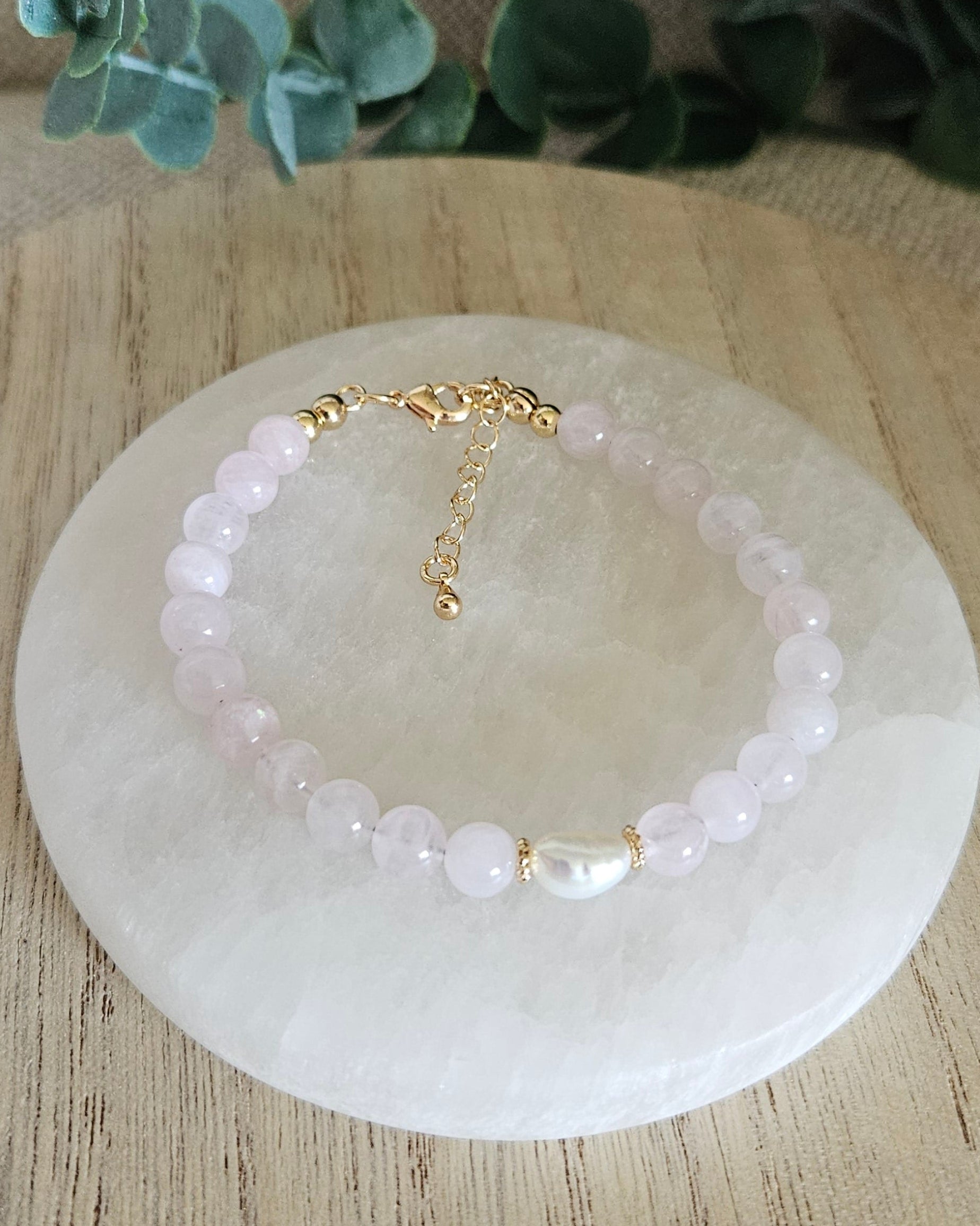 Overhead view of the Rose Quartz Embrace bracelet with freshwater pearl focal, clasp and extender chain