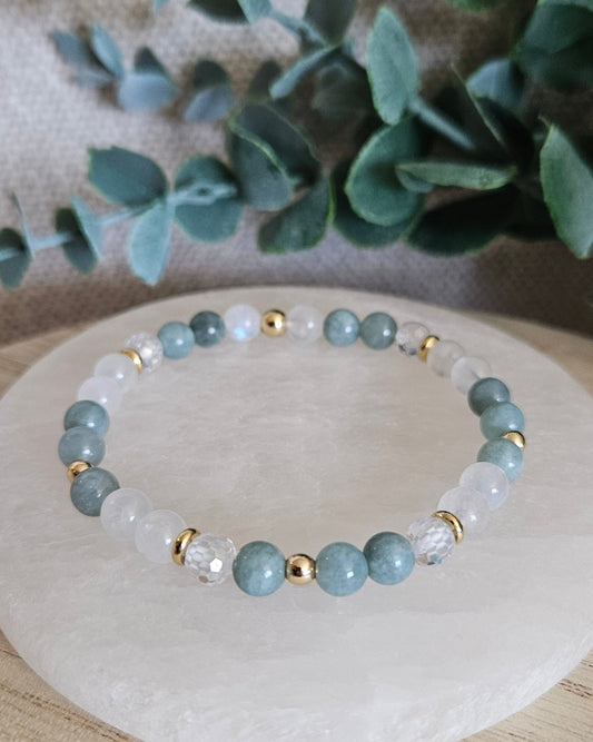 Sage Green Jade and Moonstone stretch bracelet with faceted Cubic Zirconia accent and gold spacers on selenite
