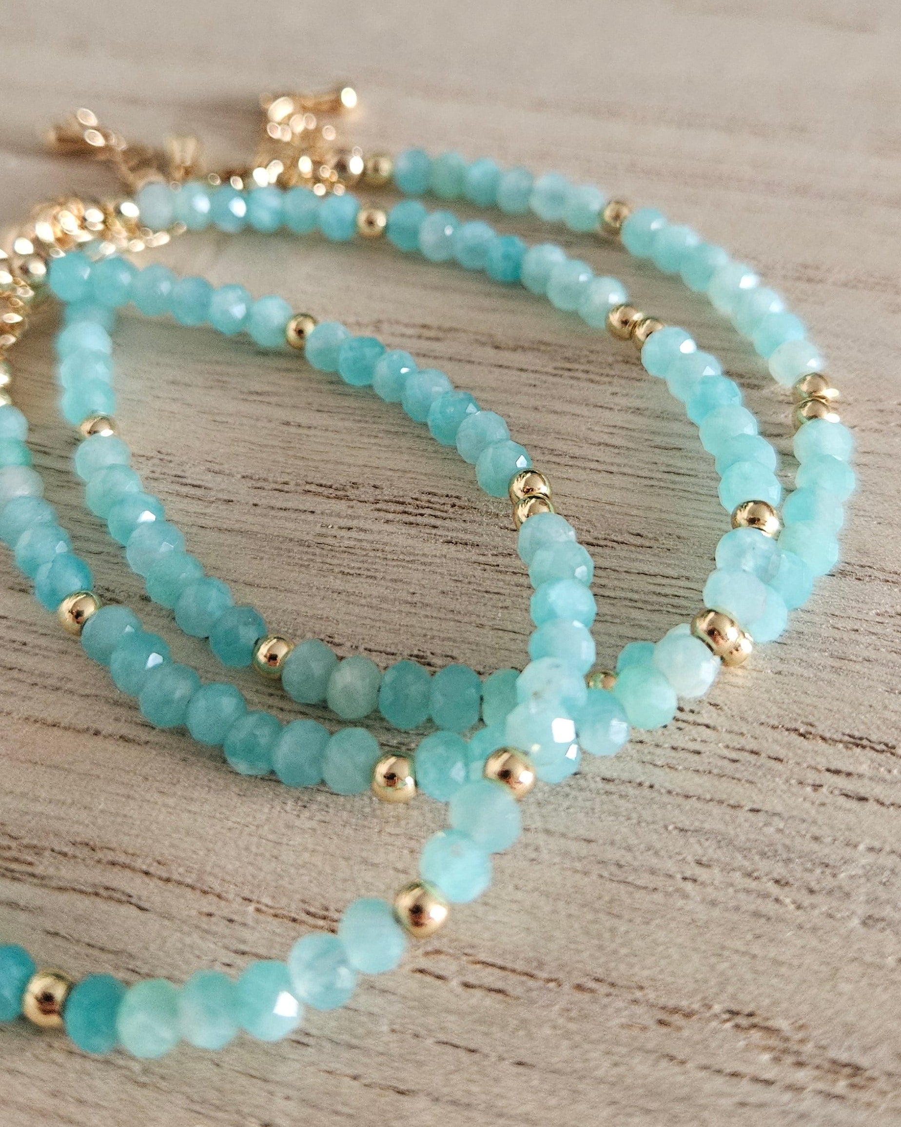 Several layered Mozambique Amazonite bracelets with gold-plated accents and extender chains