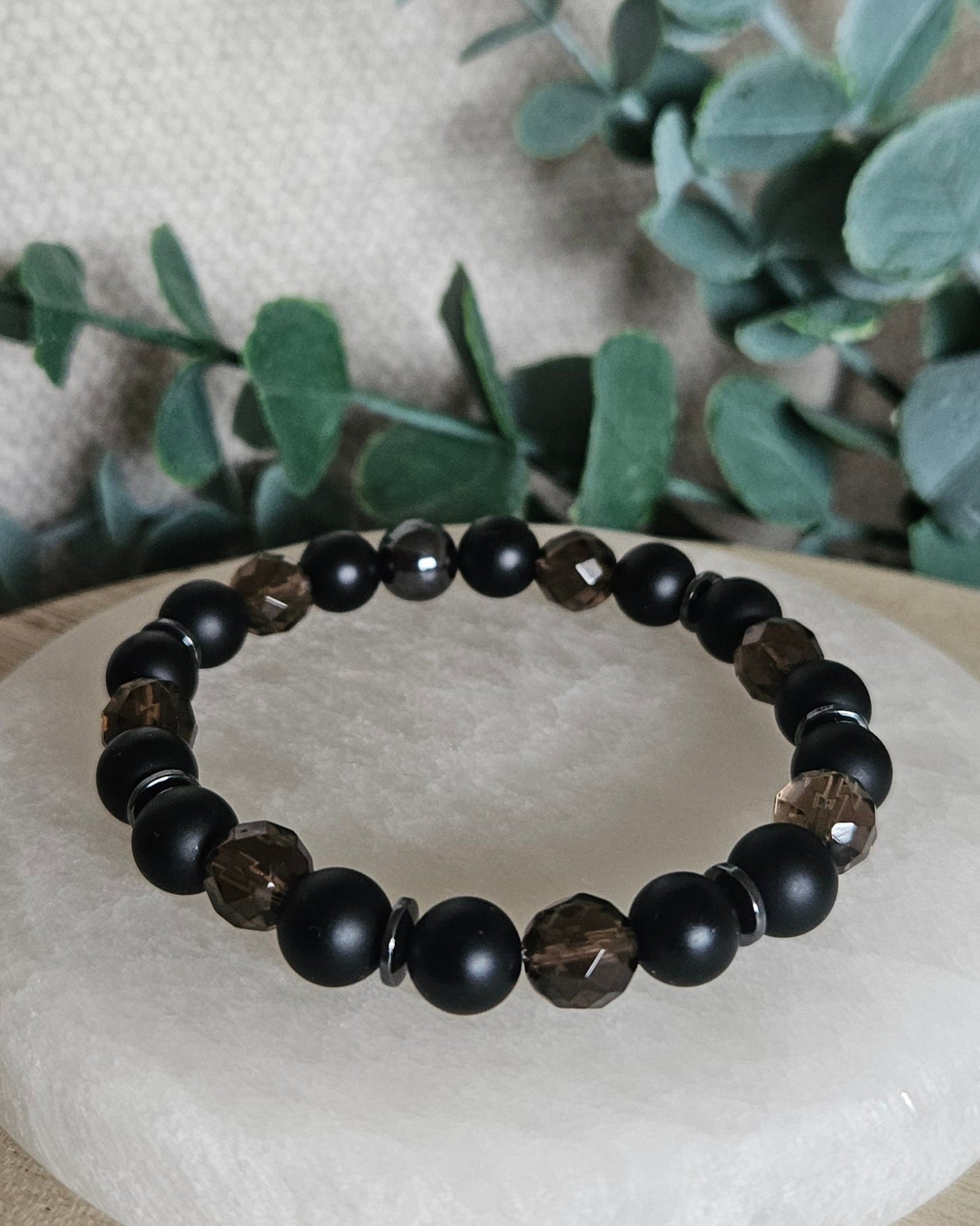 Smoky Quartz, matte Black Onyx and Hematite stretch bracelet with gunmetal spacers displayed on selenite