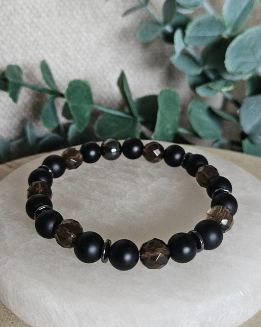 Smoky Quartz, matte Black Onyx and Hematite stretch bracelet with gunmetal spacers displayed on selenite