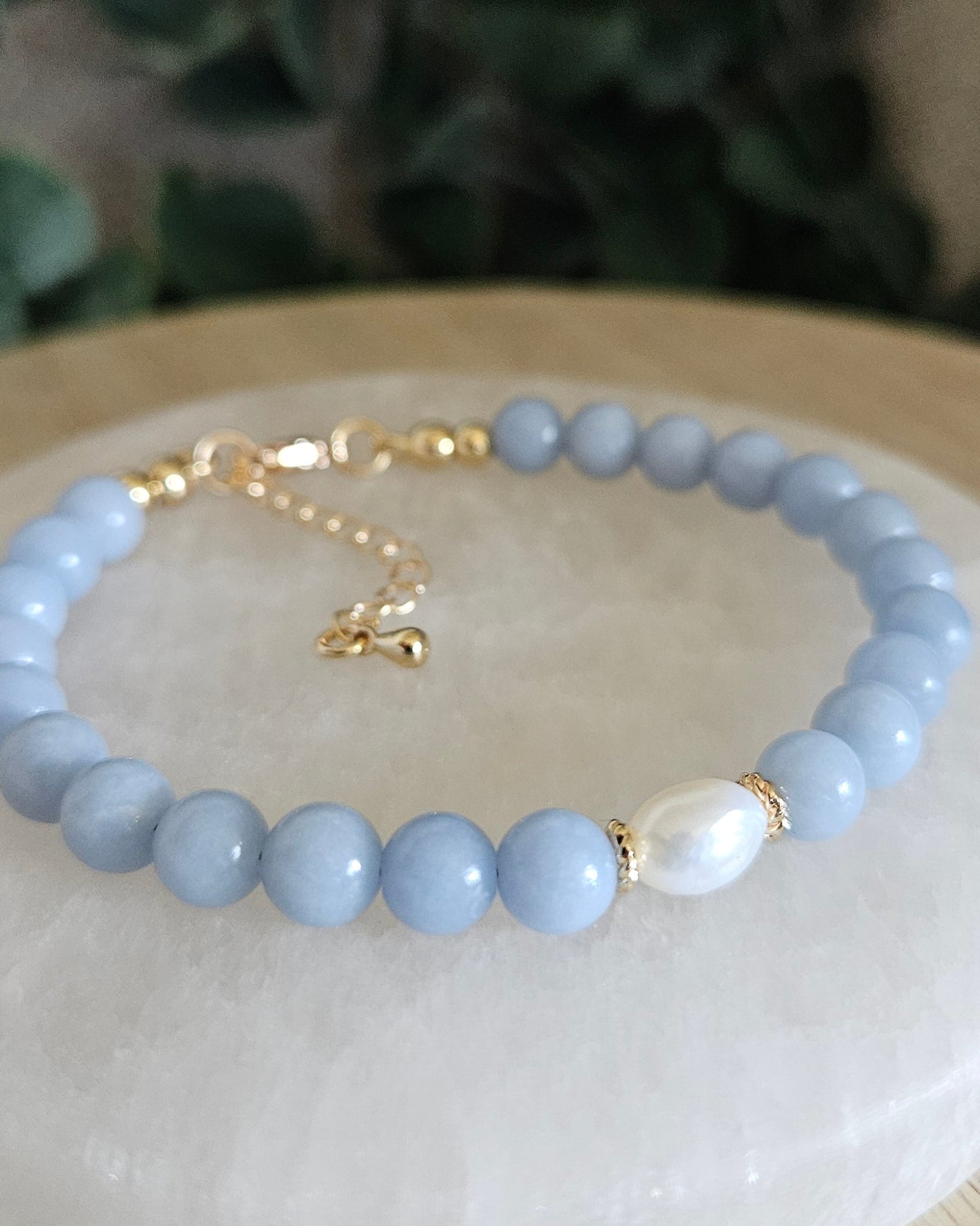 Close-up of Angelite beads and a freshwater pearl focal with gold-plated floral spacers