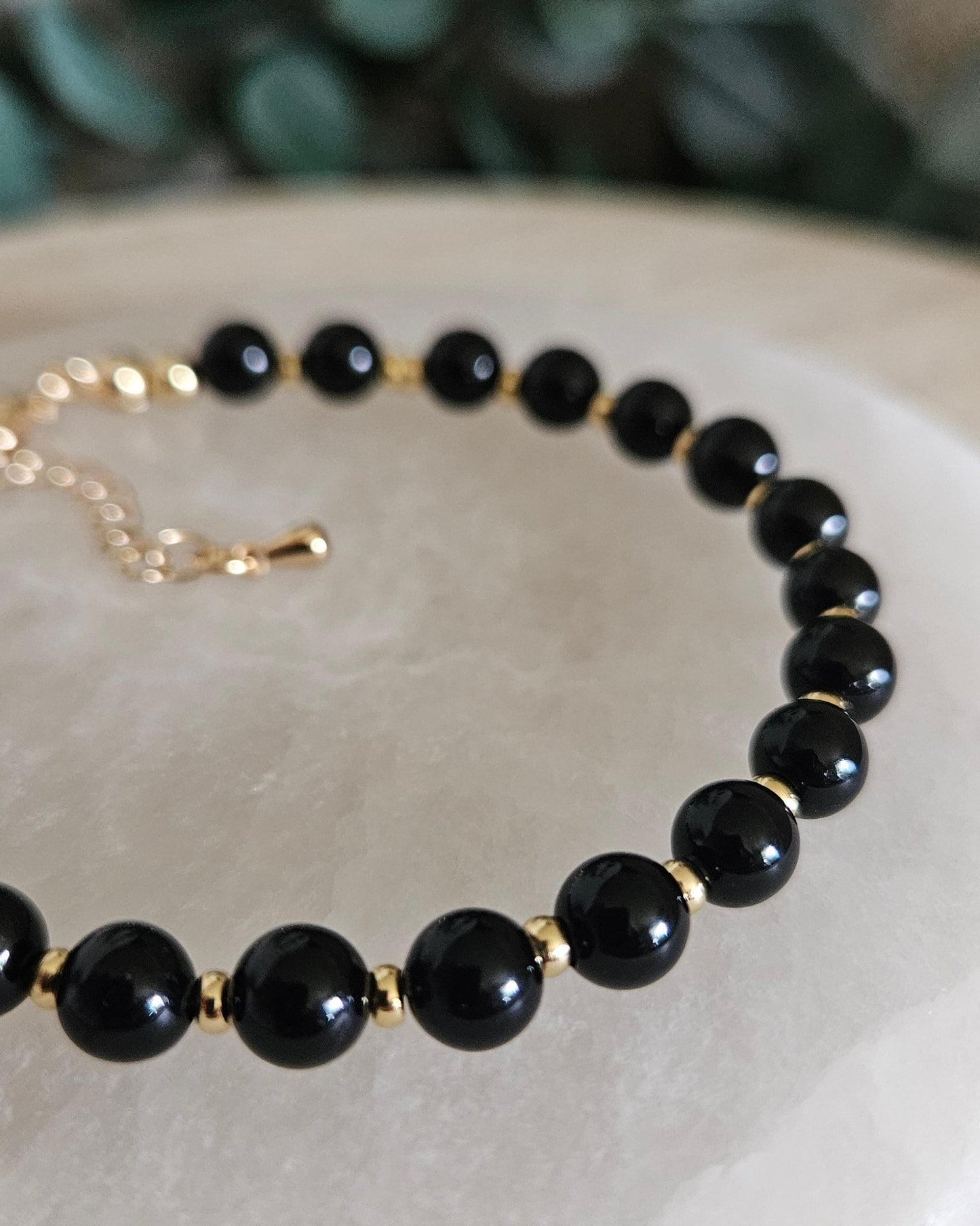 Close-up of glossy Black Onyx beads and gold-plated spacers on the Echo bracelet