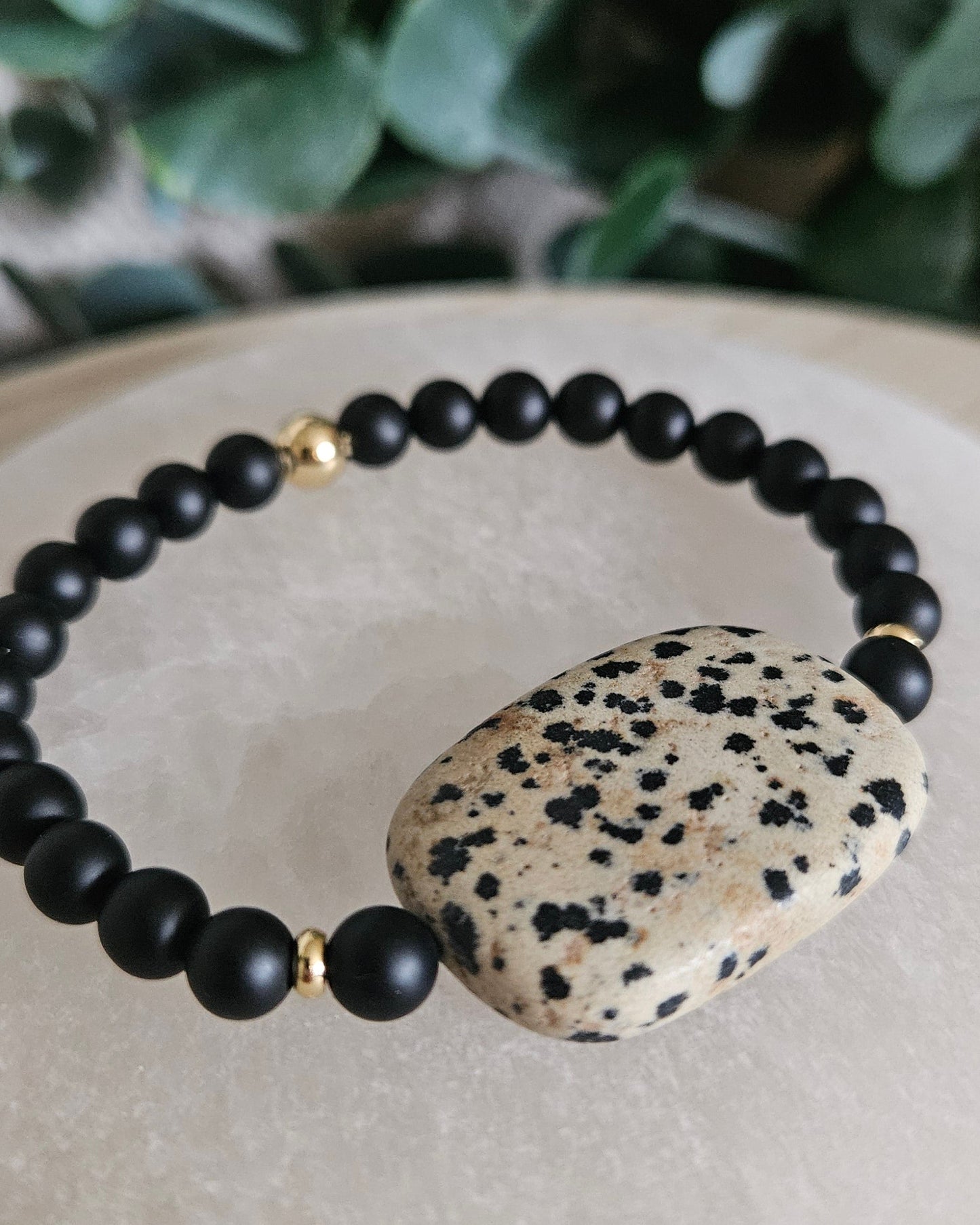 Close-up of the cream-and-black Dalmatian Jasper focal, matte Onyx beads and gold-plated accents