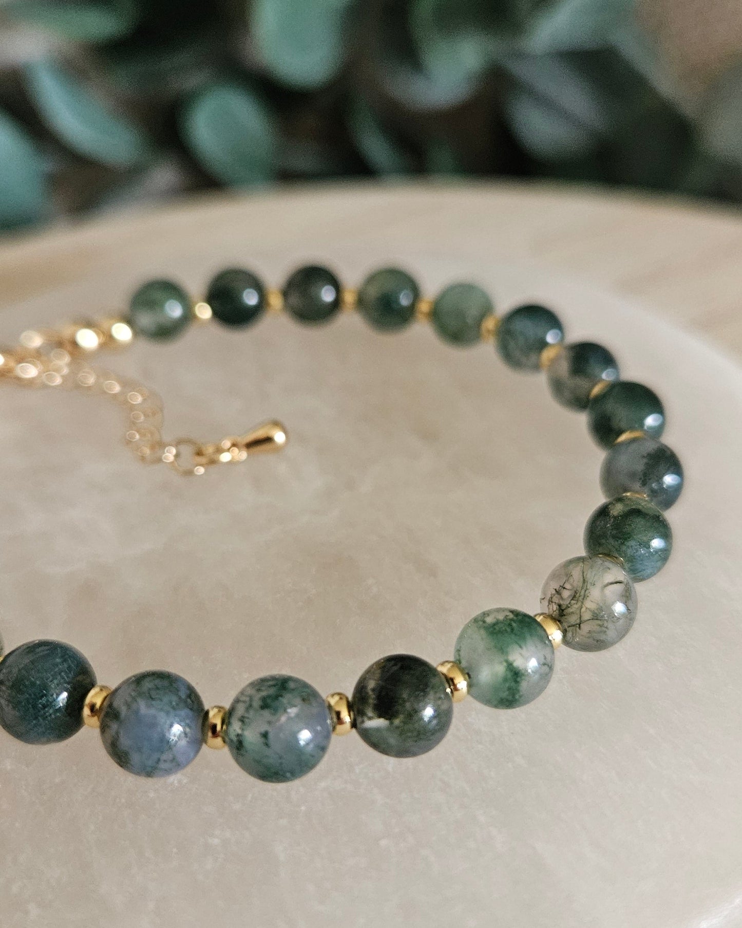 Close-up of glossy Moss Agate beads and gold-plated spacers on the Echo bracelet
