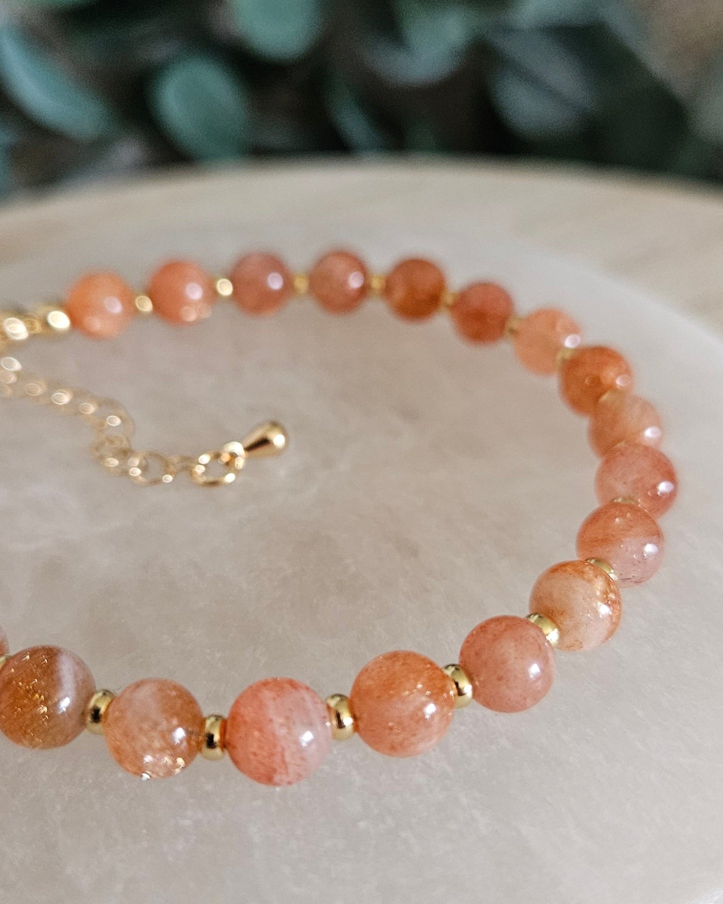 Close-up of glossy Sunstone beads and gold-plated spacers on the Echo bracelet