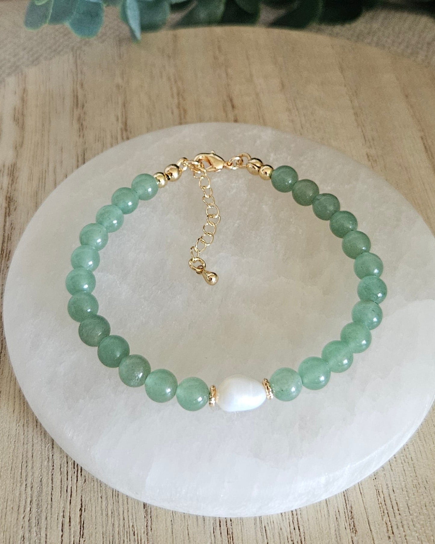 Overhead view of the Green Aventurine Embrace bracelet with freshwater pearl focal, clasp and extender chain