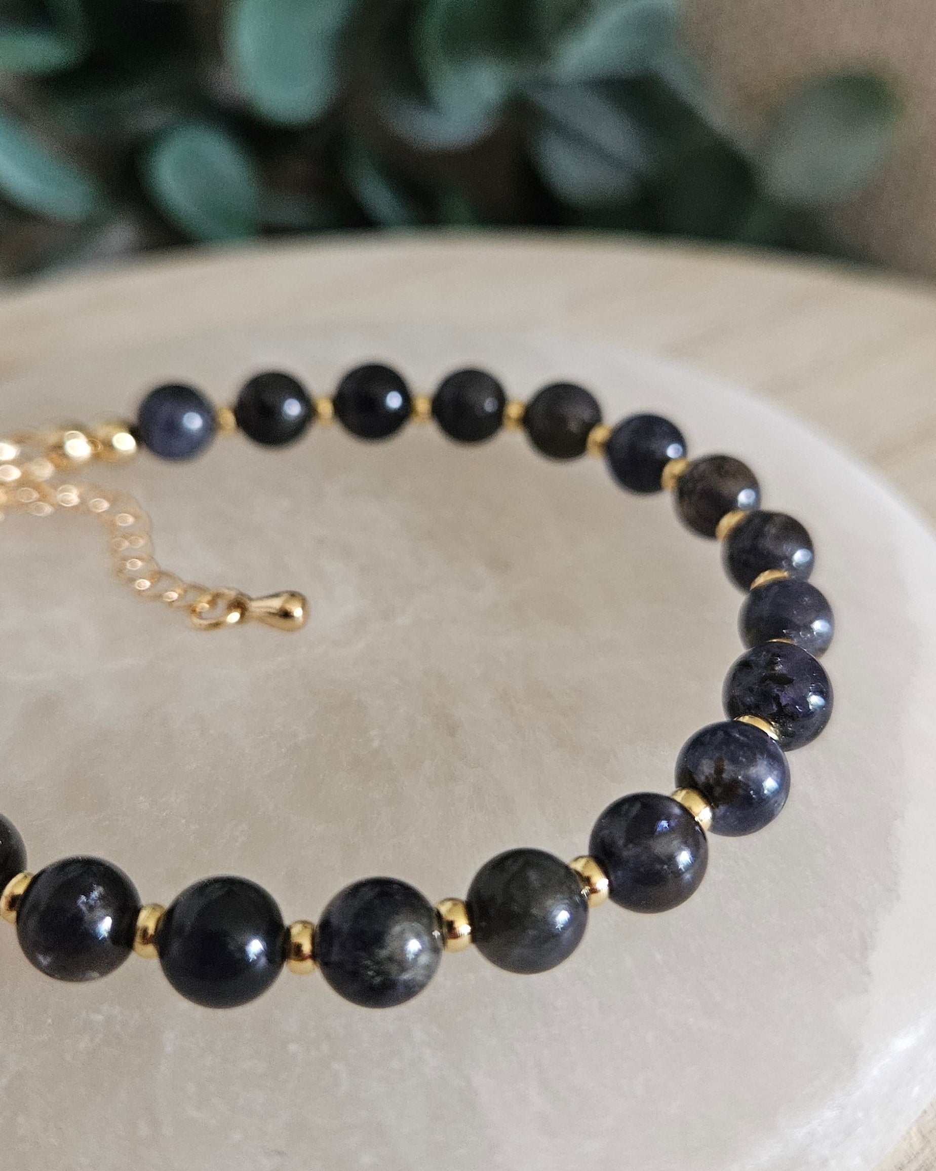 Close-up of dark blue Iolite beads and gold-plated spacers on the Echo bracelet