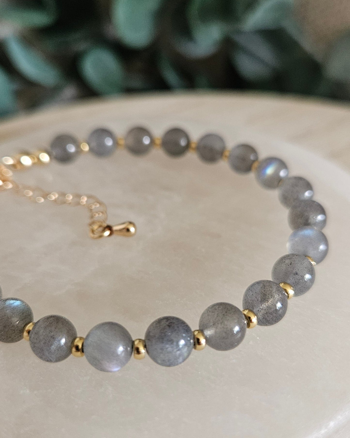 Close-up of grey Labradorite beads with blue flashes and gold-plated spacers on the Echo bracelet