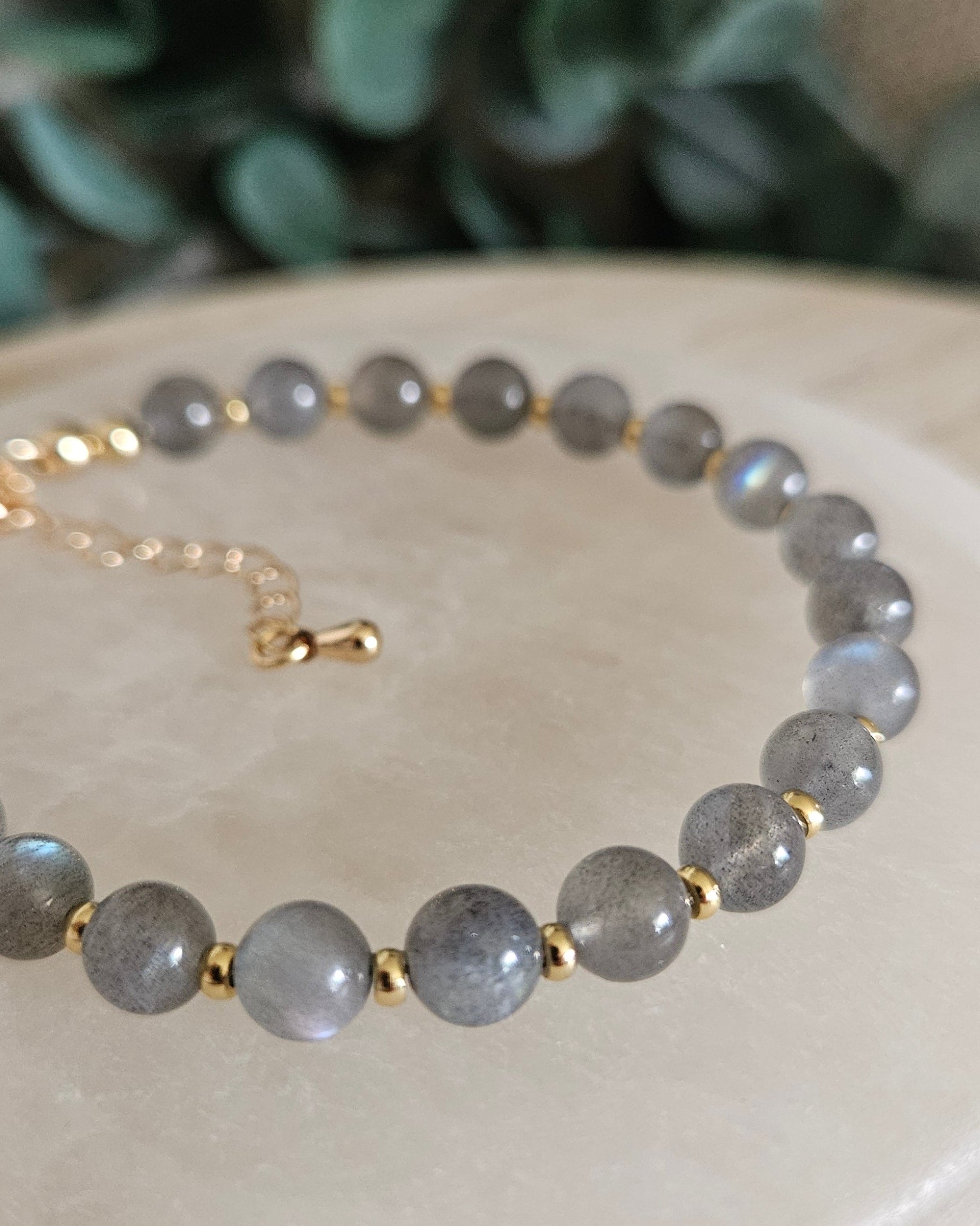 Close-up of grey Labradorite beads with blue flashes and gold-plated spacers on the Echo bracelet
